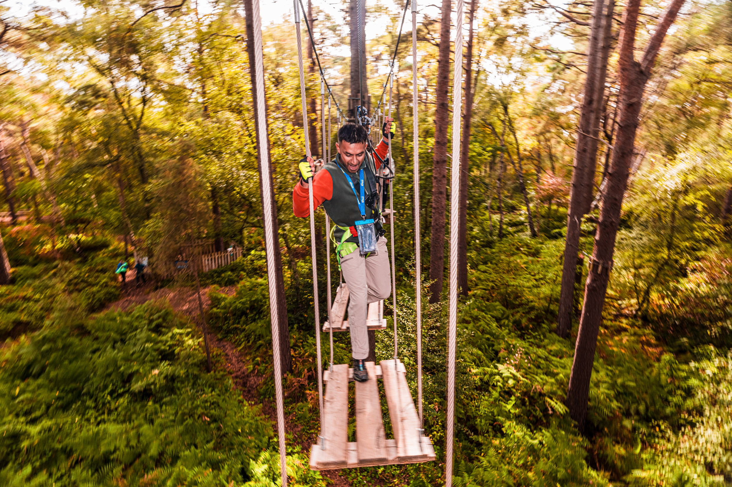 A man makes his way over a wobbly high ropes crossing on a  fun day out