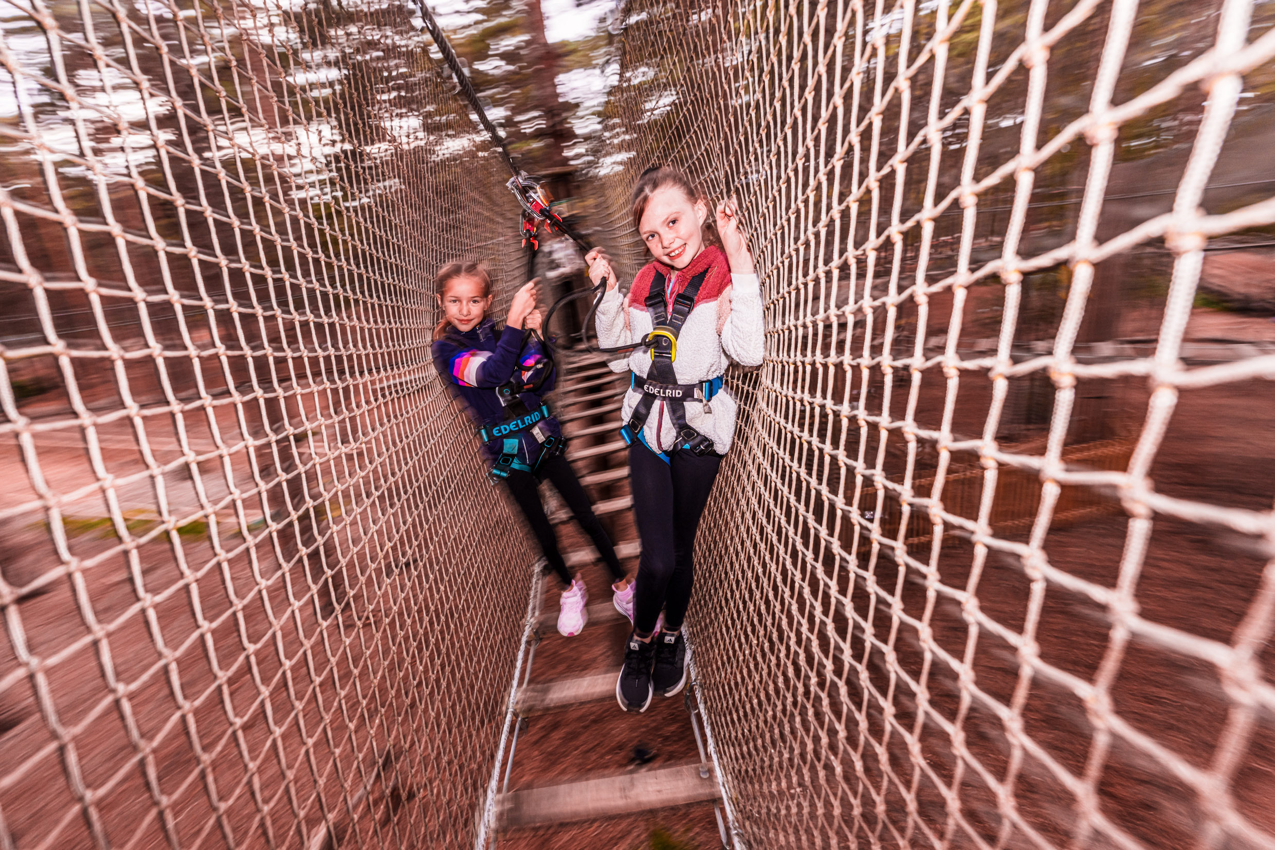 Two girls enjoy a high ropes adventure on their fun day out at Go Ape