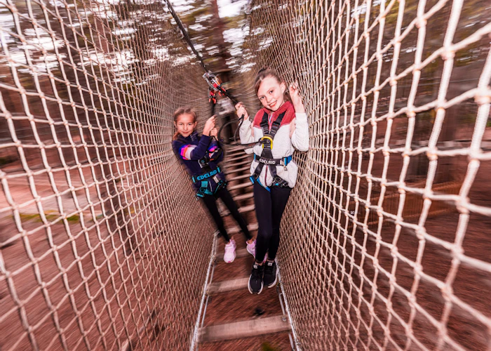Two girls enjoy a high ropes adventure on their fun day out at Go Ape
