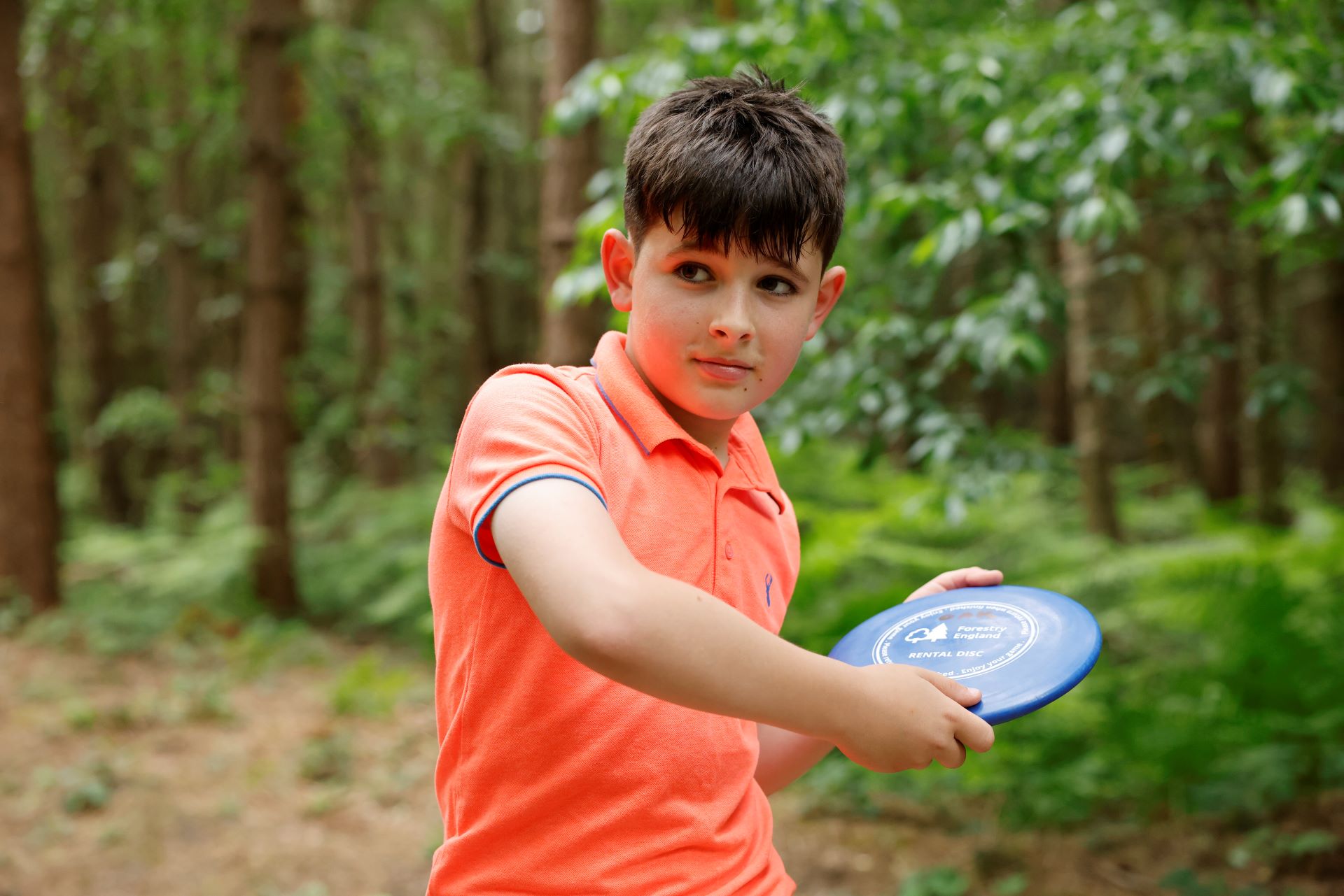 A boy playing disc golf