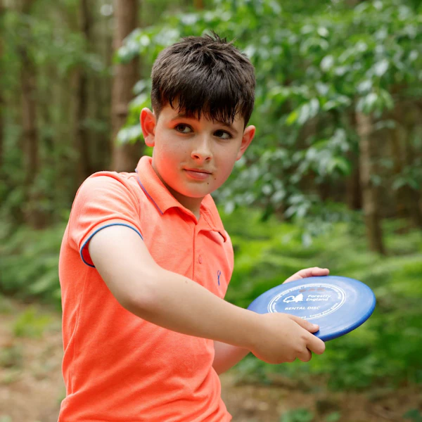 A boy playing disc golf