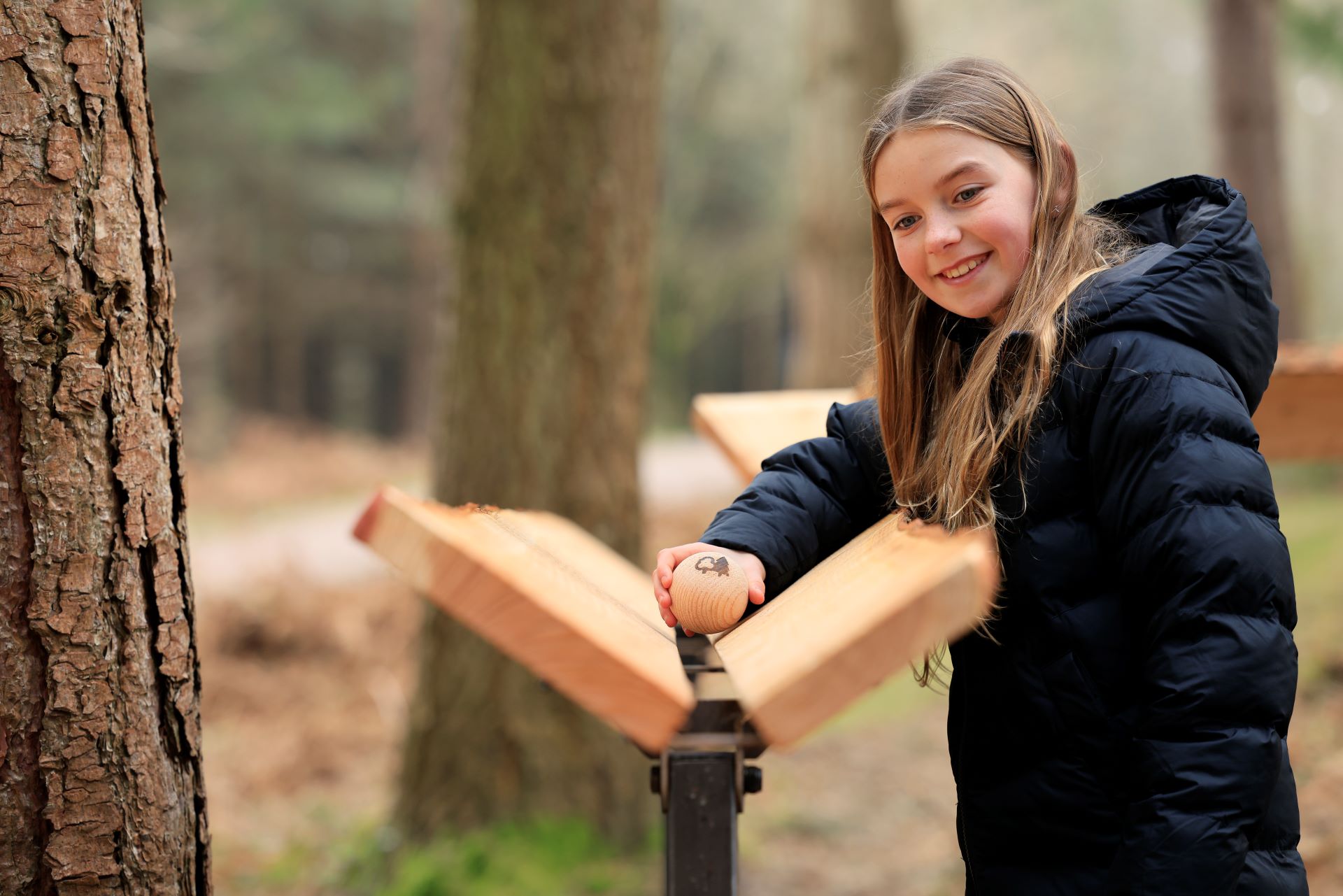 A girls plays on the Marble Run at Alice Holt