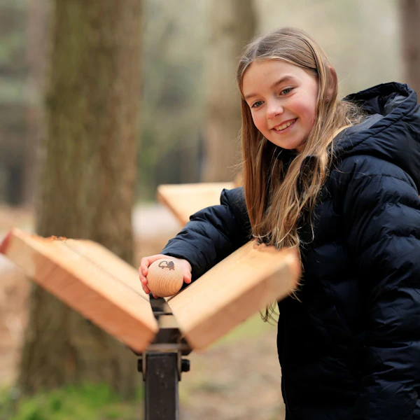 A girls plays on the Marble Run at Alice Holt