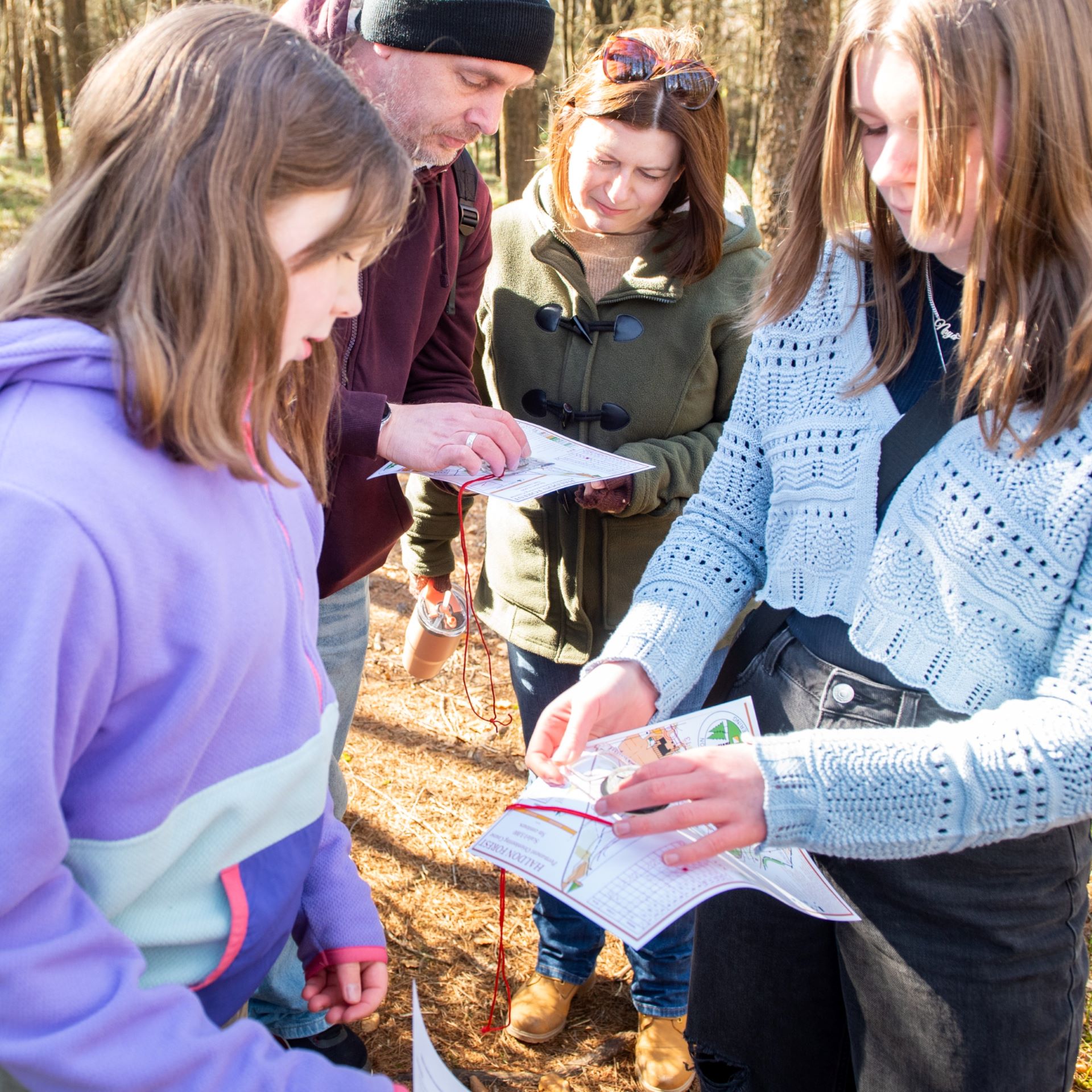 A group with a map and compass in the forest