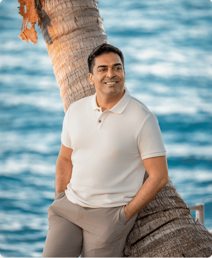 Dr. Nathan leaning against a palm tree