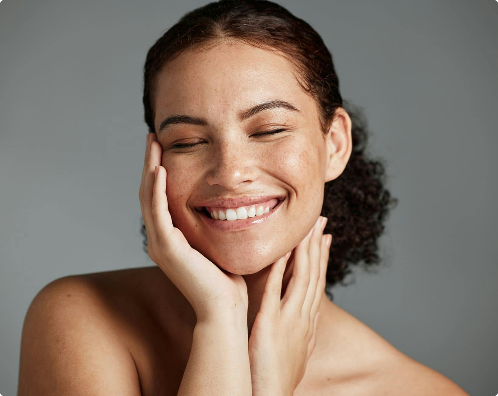 Woman smiling holding her face