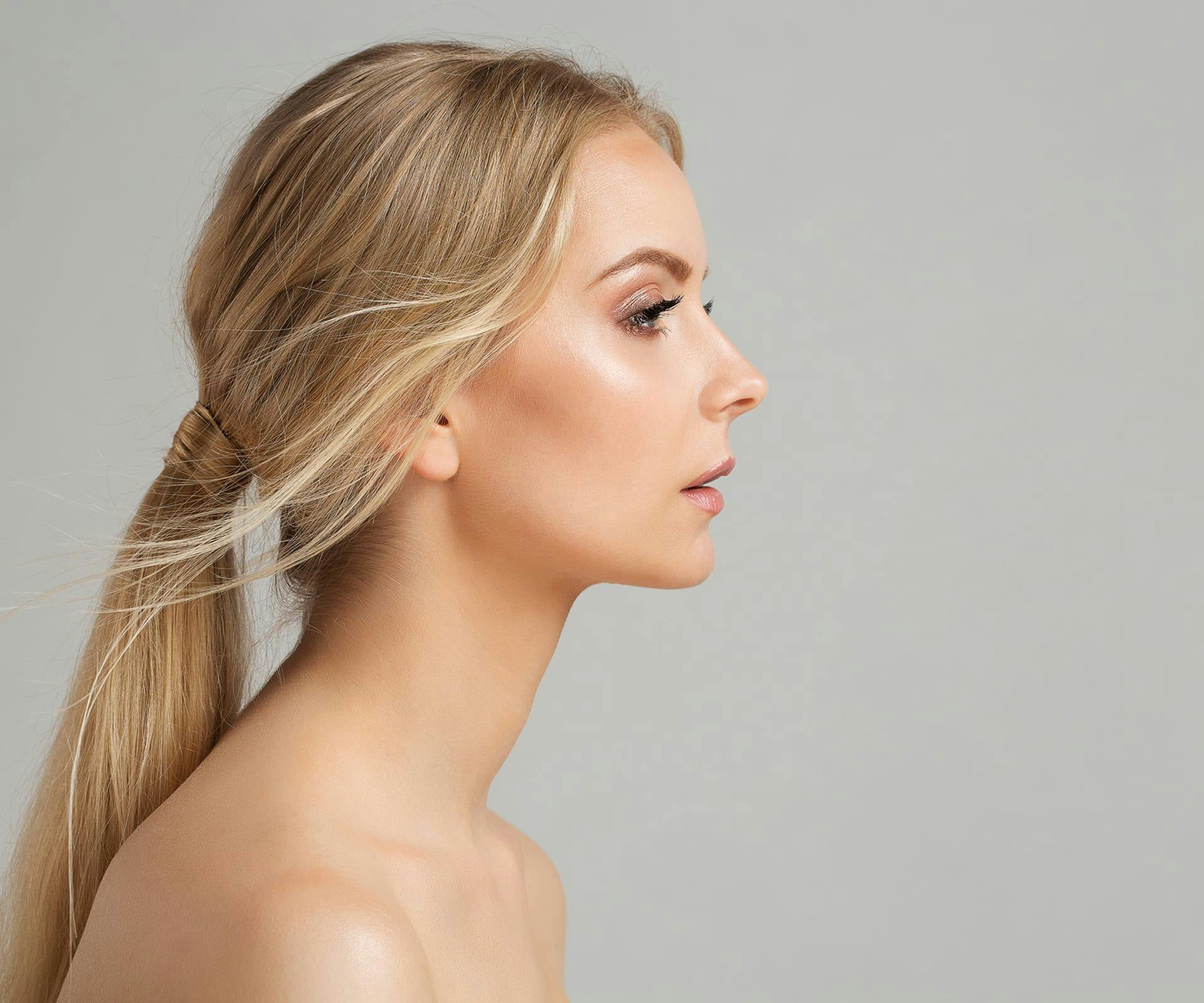 side profile of a woman with her hair tied back