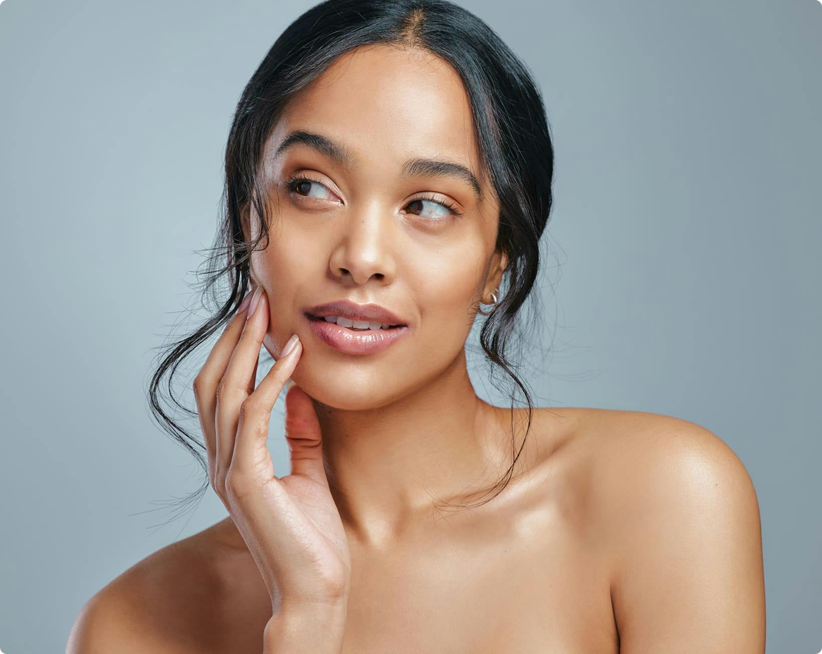 Woman looking to the side touching face