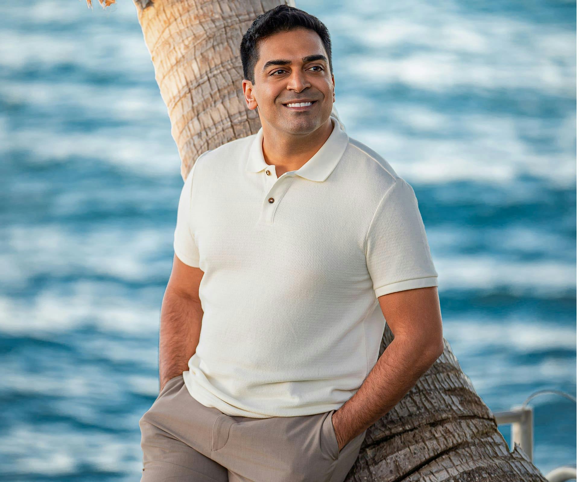 Doctor leaning on a tree smiliing