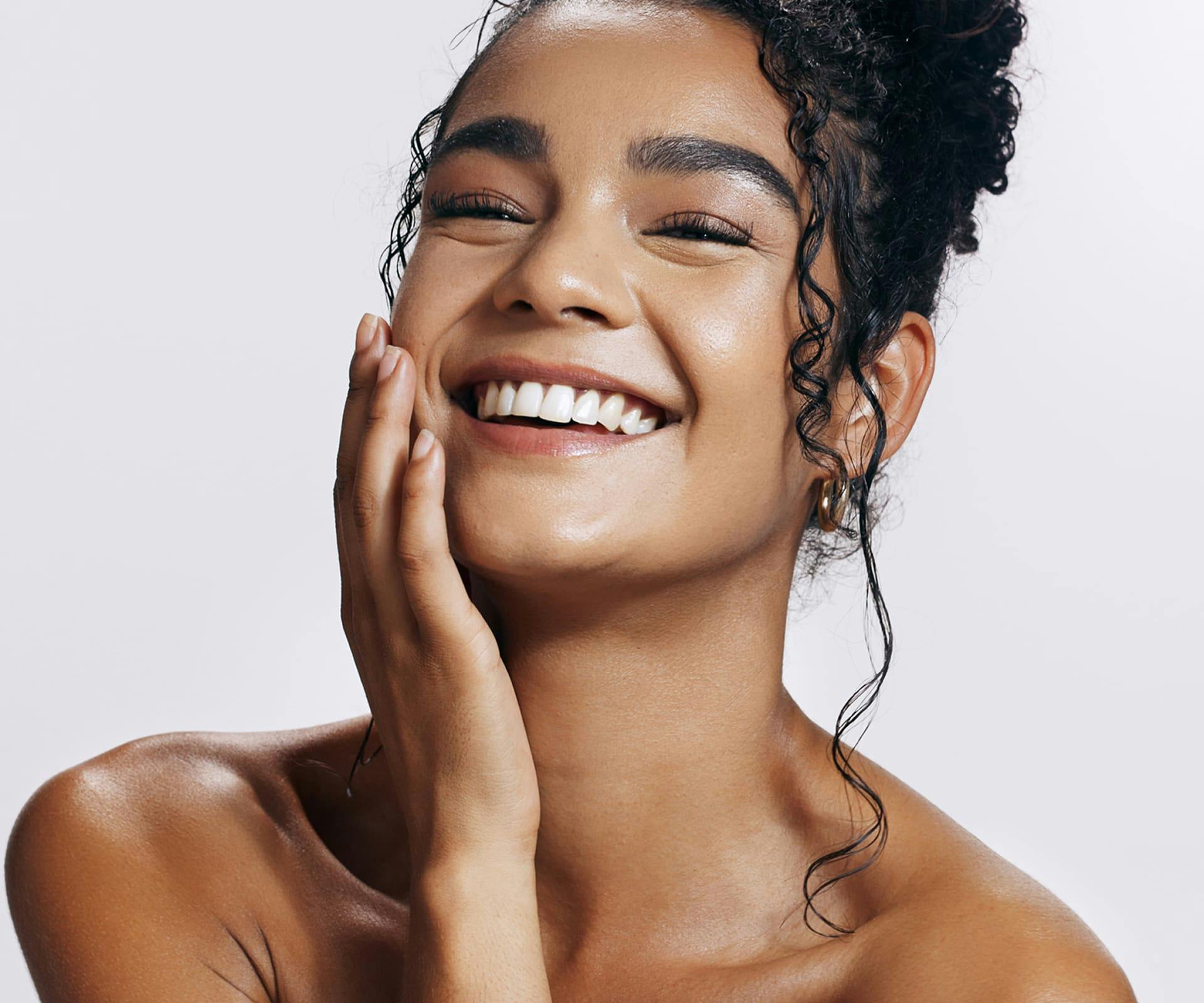 Woman touching face and smiling