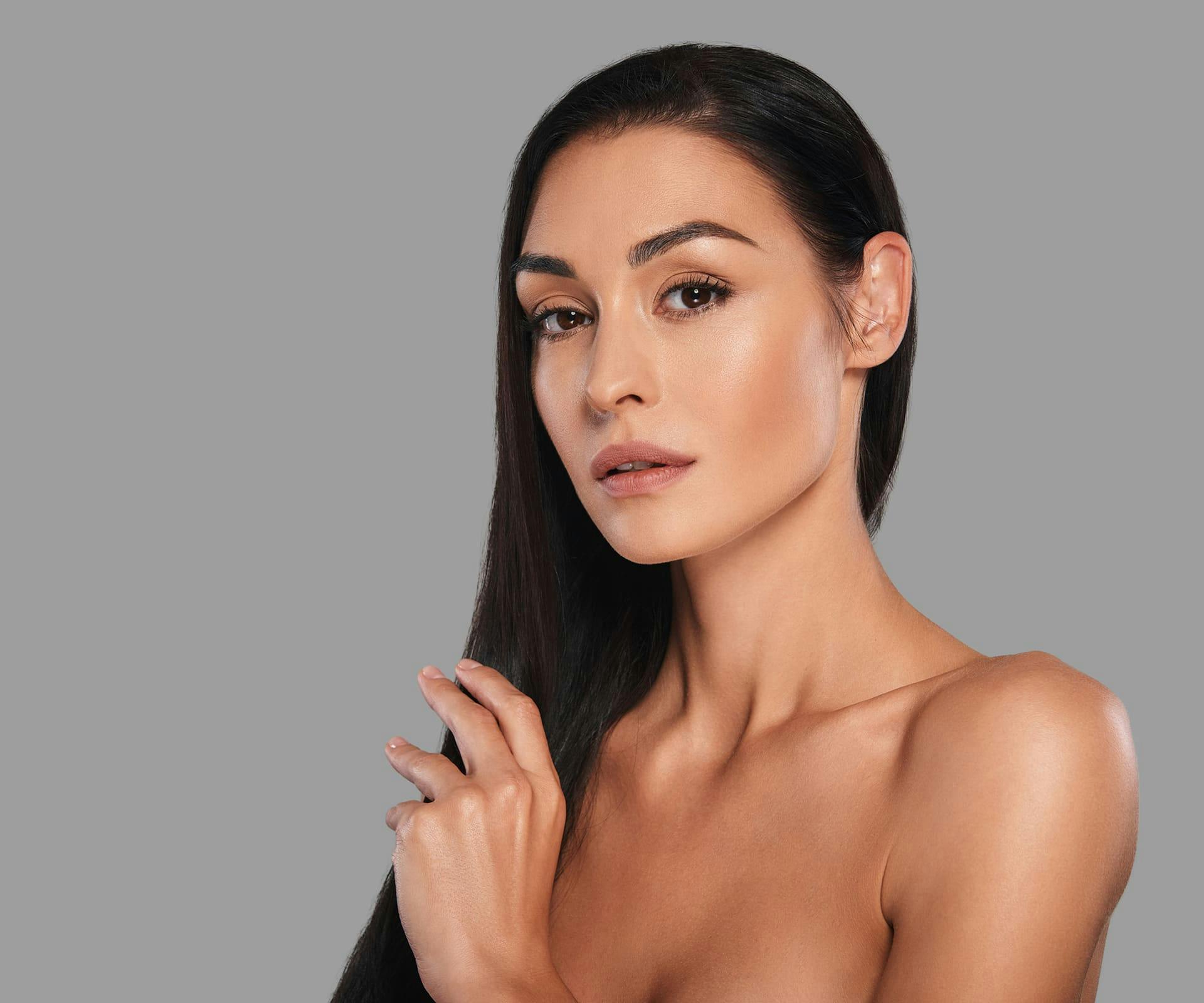 brunette woman with trimmed eyebrows looking forward