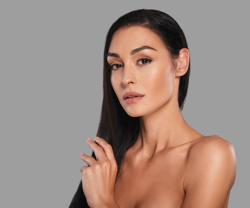 brunette woman with trimmed eyebrows looking forward