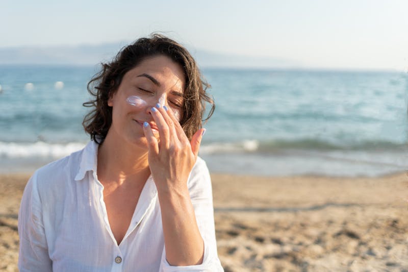 Woman applying sunscreen at the beach