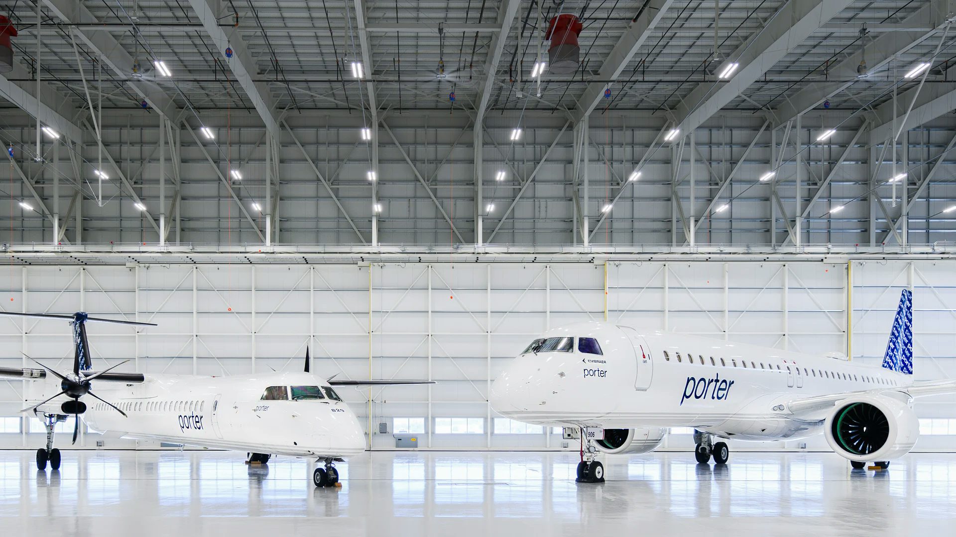 À gauche, un Dash 8-Q400 et à droite, un Embraer E195-E2, tous deux des avions de Porter Airlines dans leur hangar