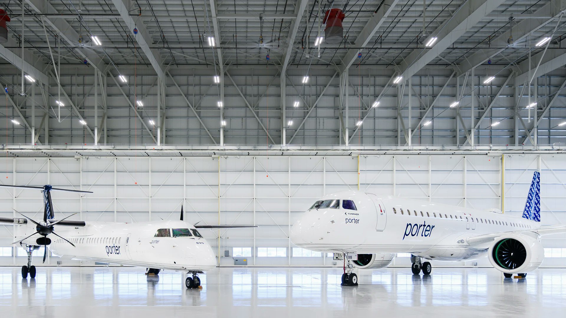 À gauche, un Dash 8-Q400 et à droite, un Embraer E195-E2, tous deux des avions de Porter Airlines dans leur hangar