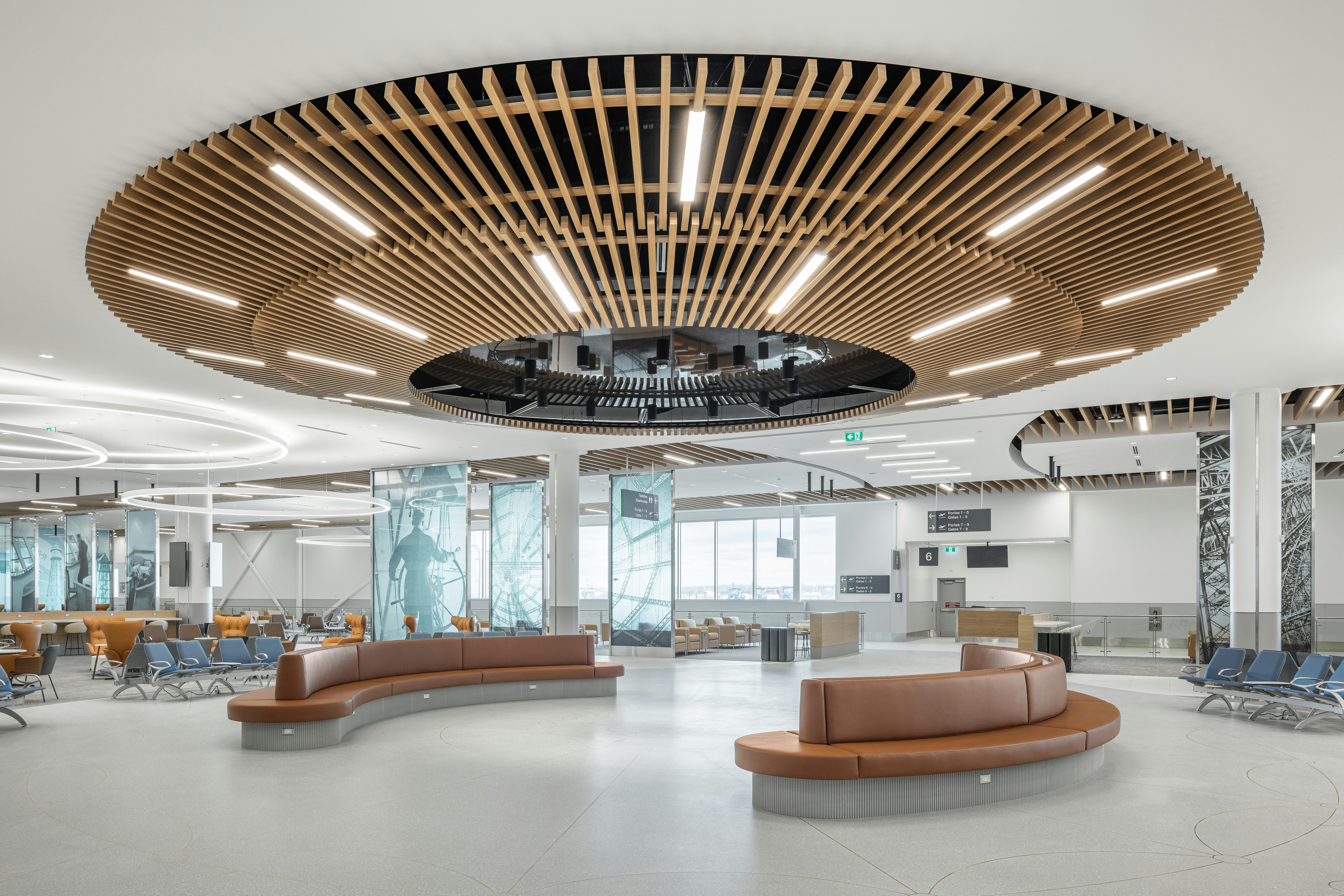 MET terminal boarding lounge with circular benches, passenger seating, and an architectural wood ceiling
