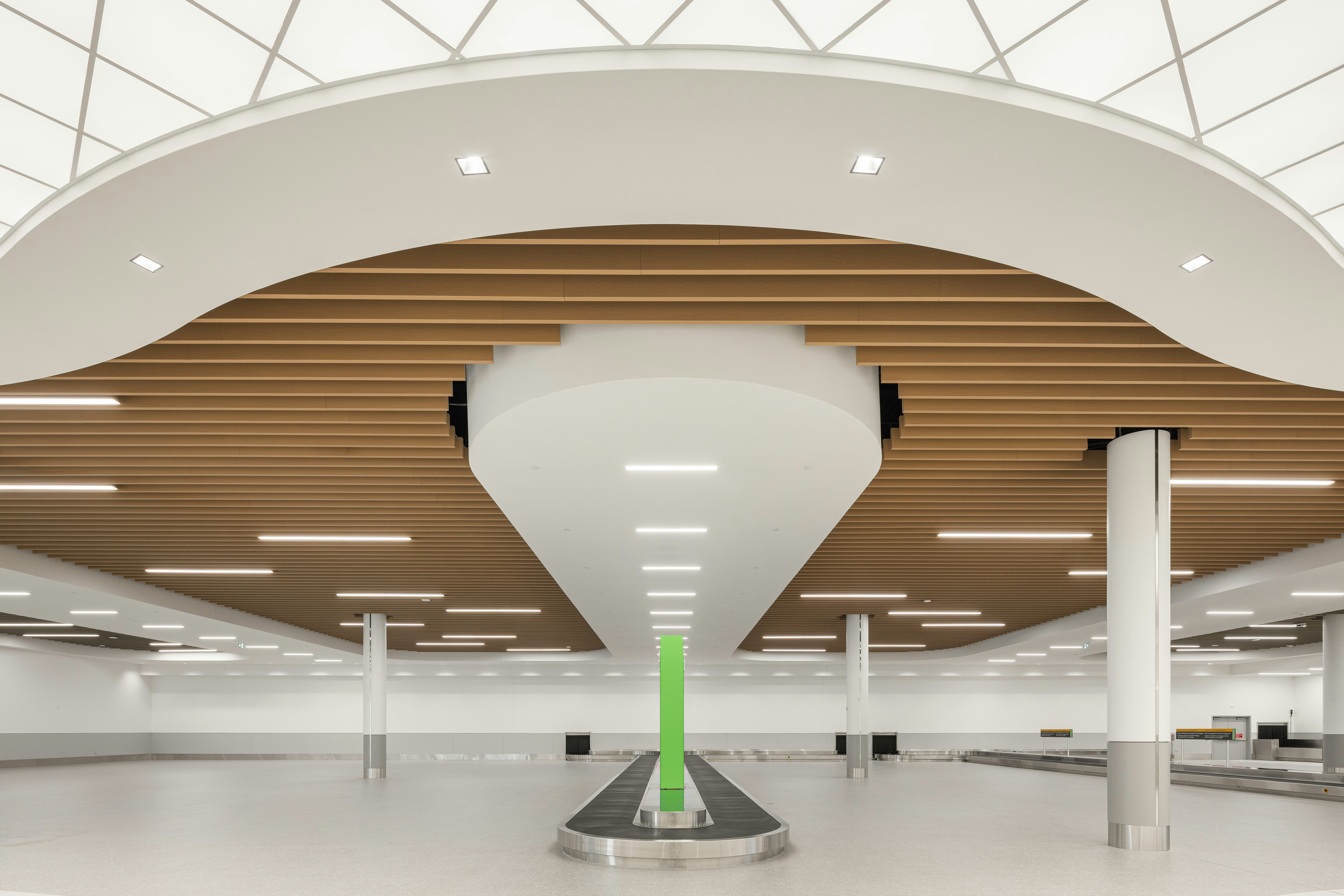 MET terminal baggage claim area with central carousel and architectural wood ceiling