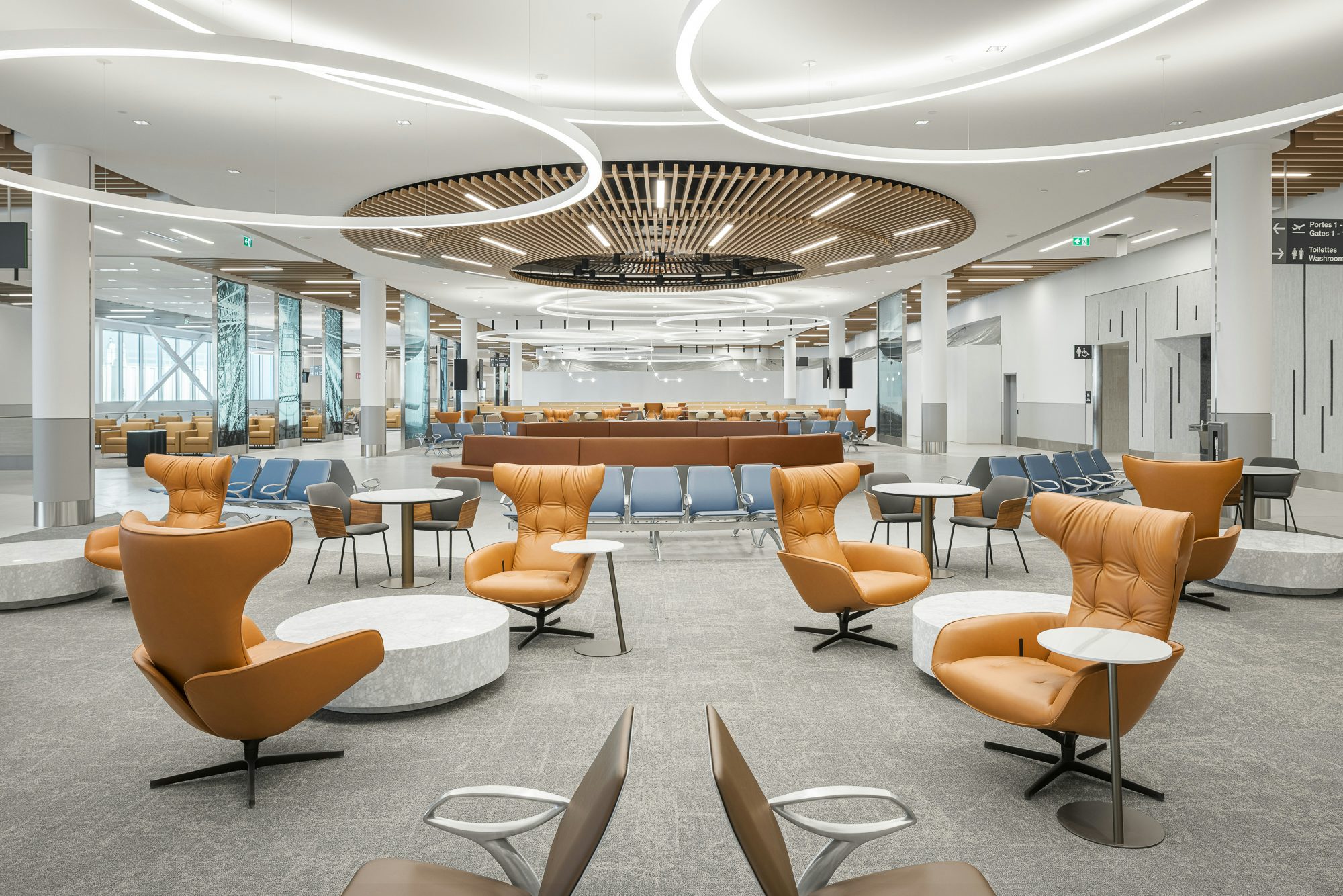 MET terminal waiting area with lounge chairs, passenger seating, and illuminated architectural ceilings