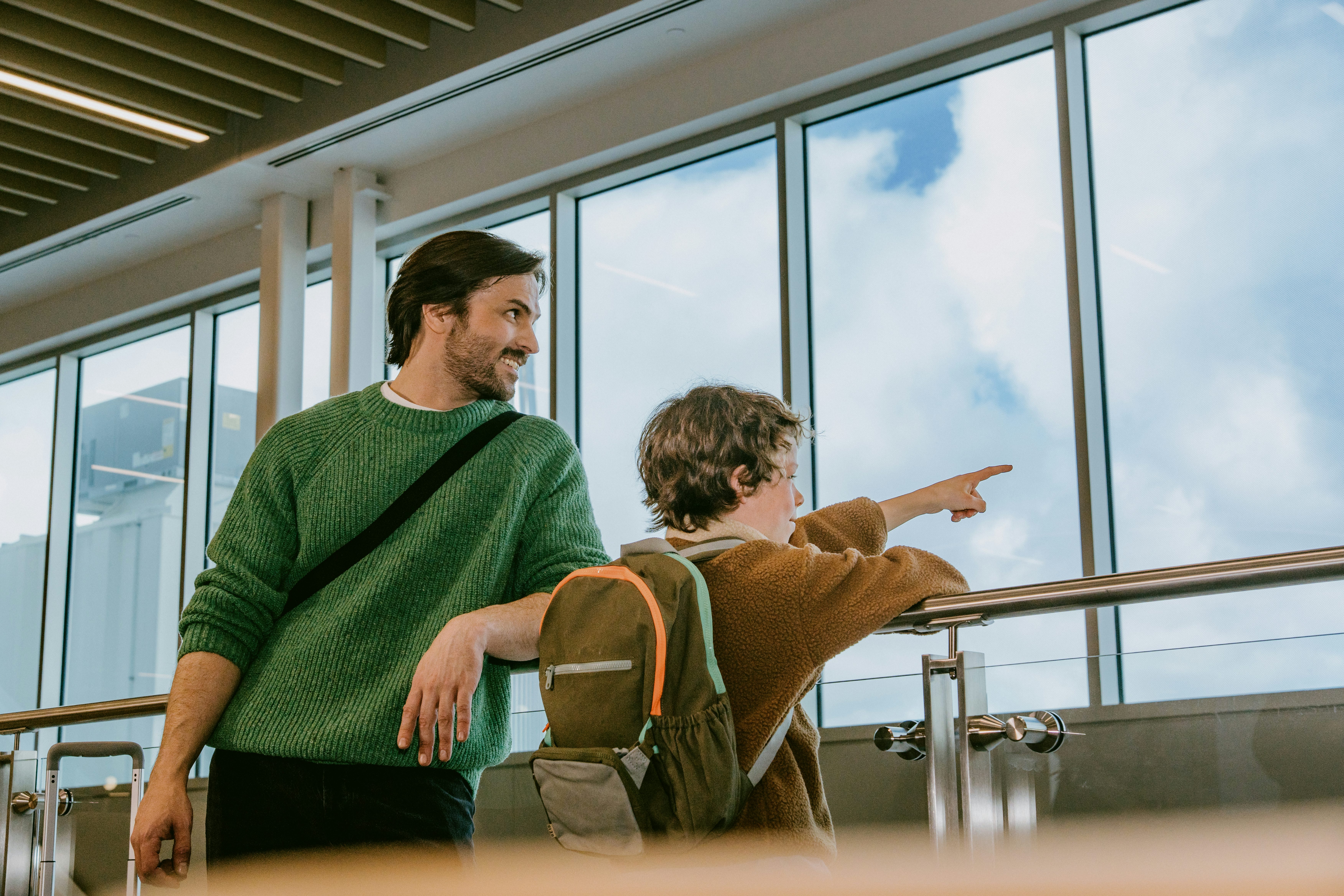 Adult and child in the MET terminal looking out the window toward the tarmac