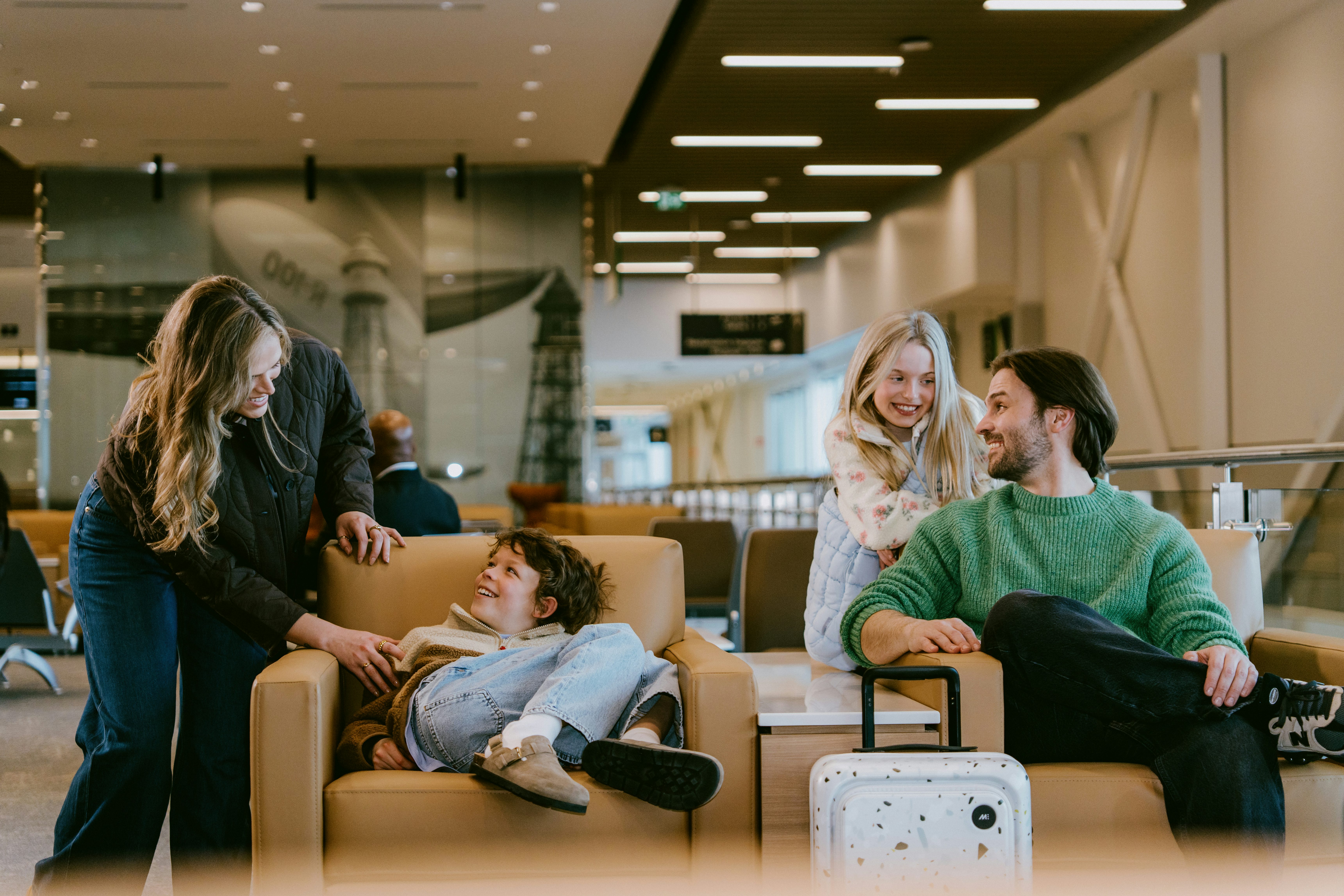 Family seated in the MET terminal waiting area with carry-on luggage