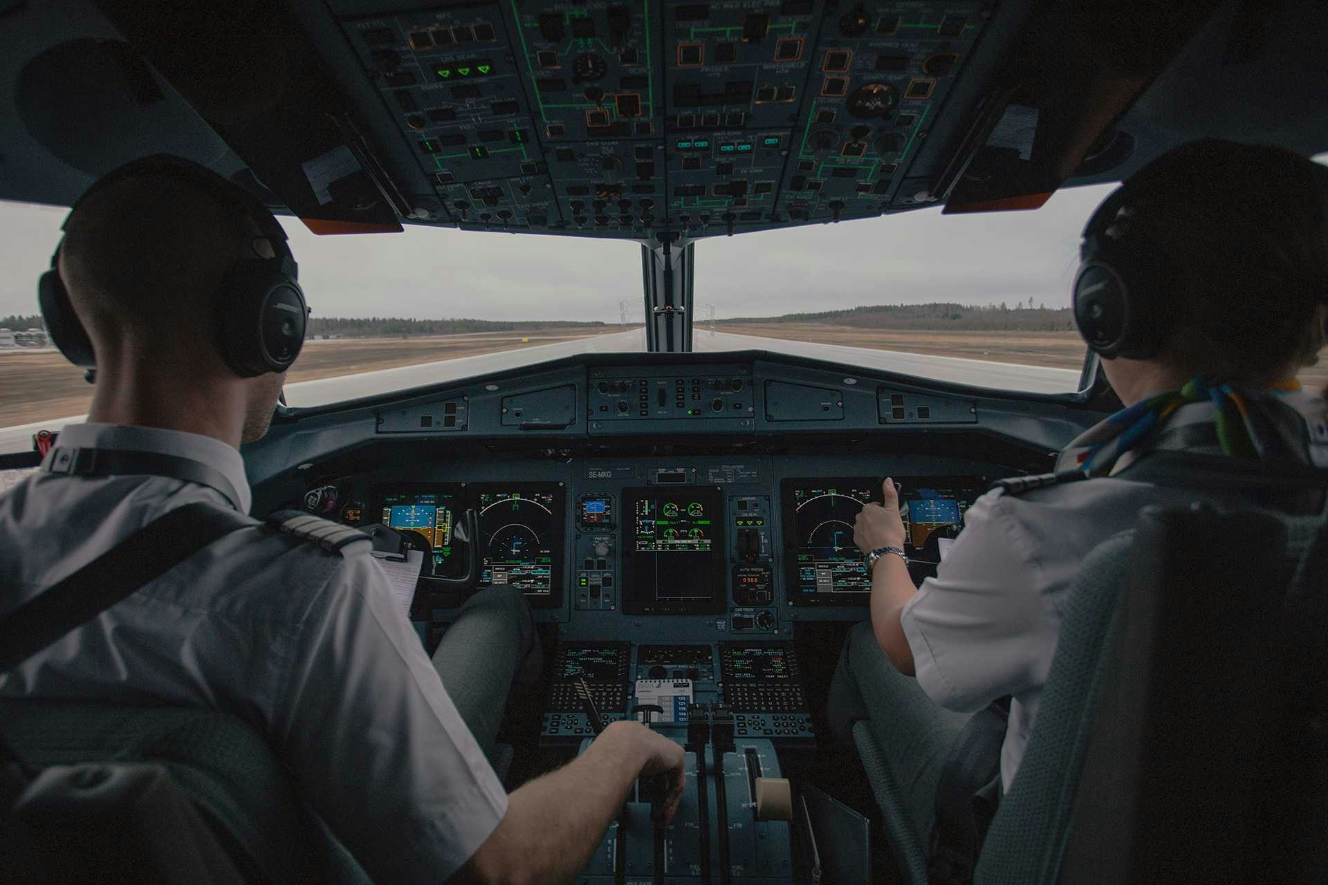 Two pilots in an aircraft cockpit preparing on the runway