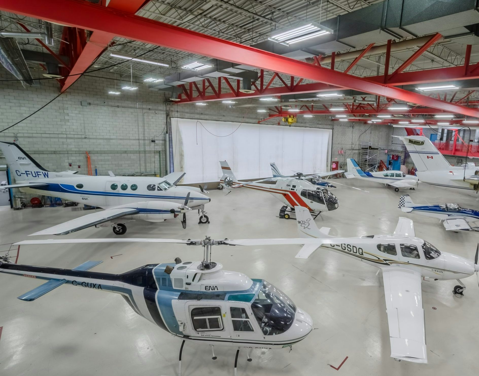 Aircraft hangar with several airplanes and helicopters parked inside