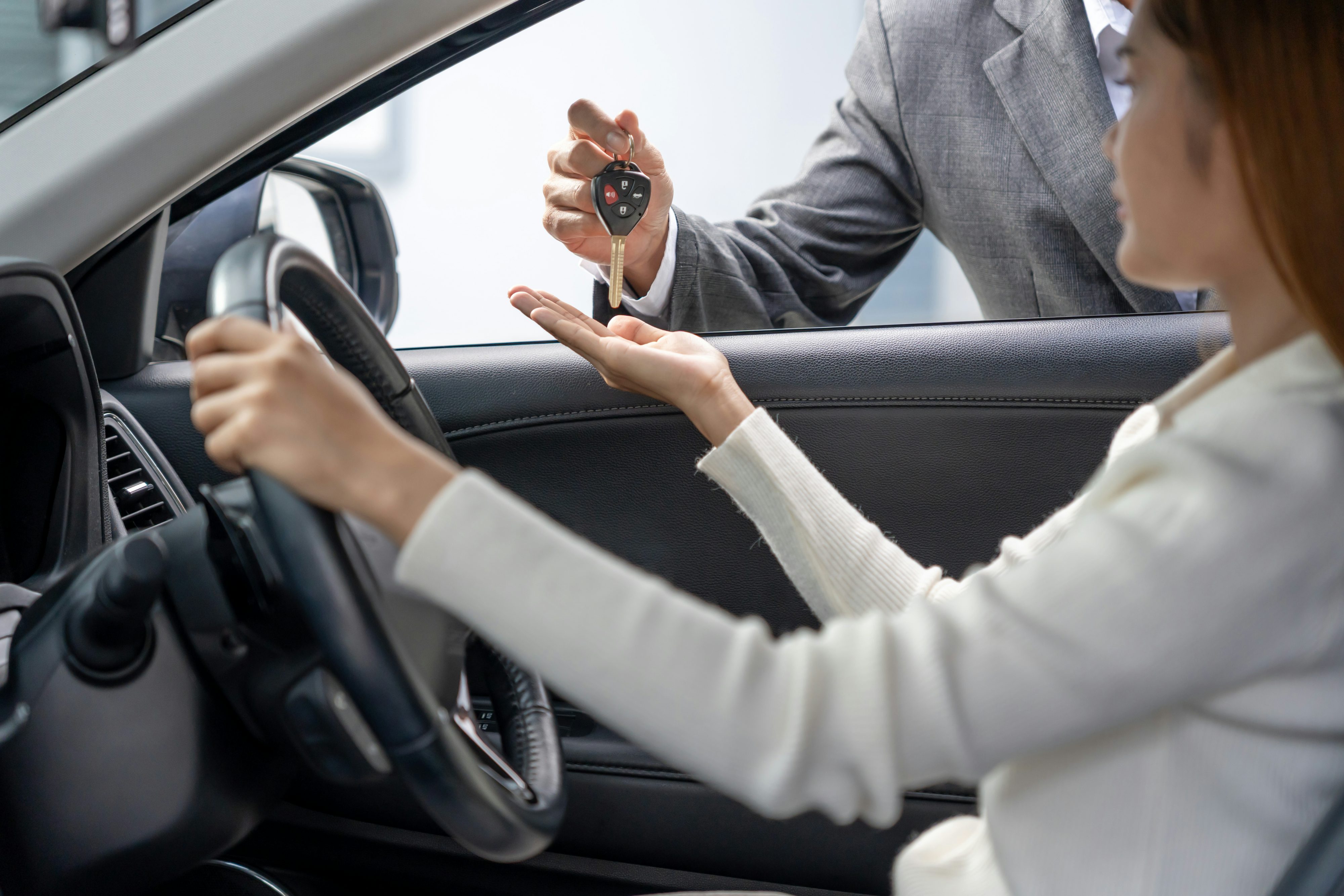 car-rental woman being handed a car key