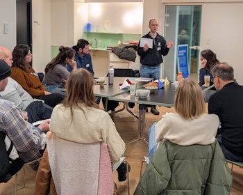 Medewerker van De Ambrassade spreekt voor een groep mensen.