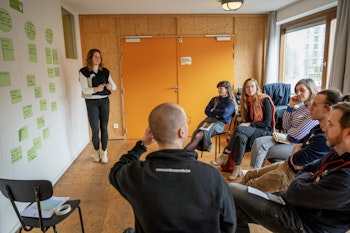 Een groep mensen die luisteren naar iemand.