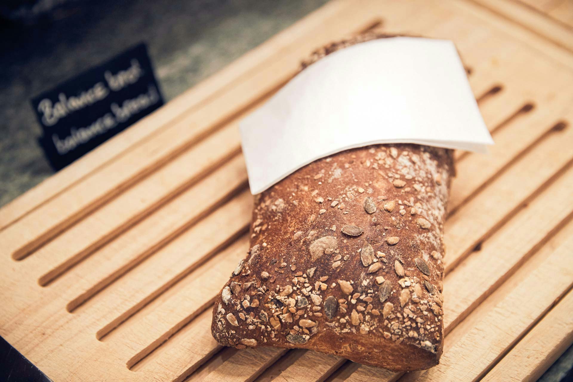 Brot auf einem Holzbrett mit weisser Serviette, Teil eines Frühstücksbuffets