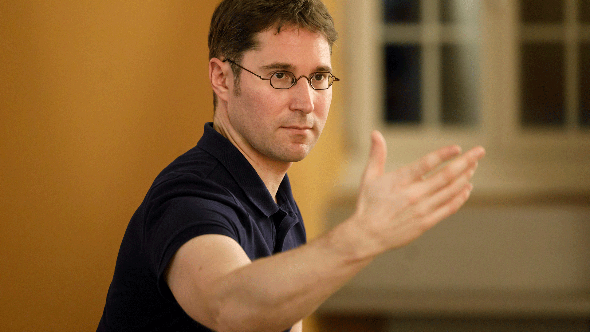Qigong im Hotel Beatus Ein Mann mit Brille zeigt eine Qigong-Übung vor