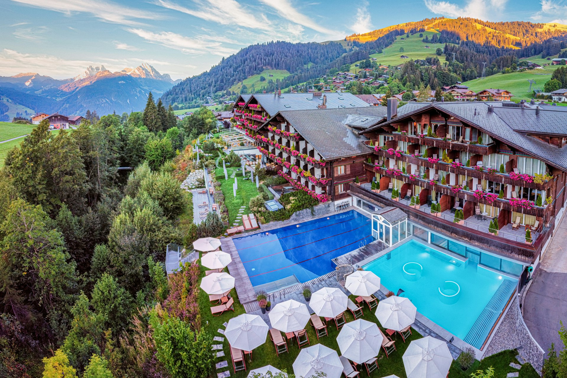 Vue par drone d'un grand complexe hôtelier avec deux piscines dans un paysage de montagne