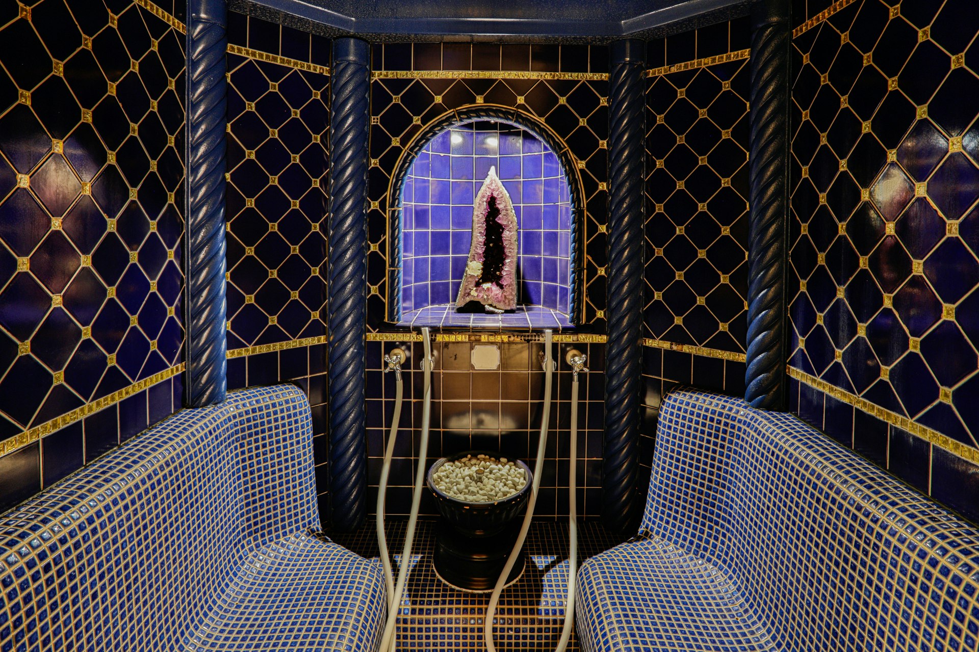 Cabine de vapeur décorée de carreaux et de mosaïques, avec une améthyste au fond.