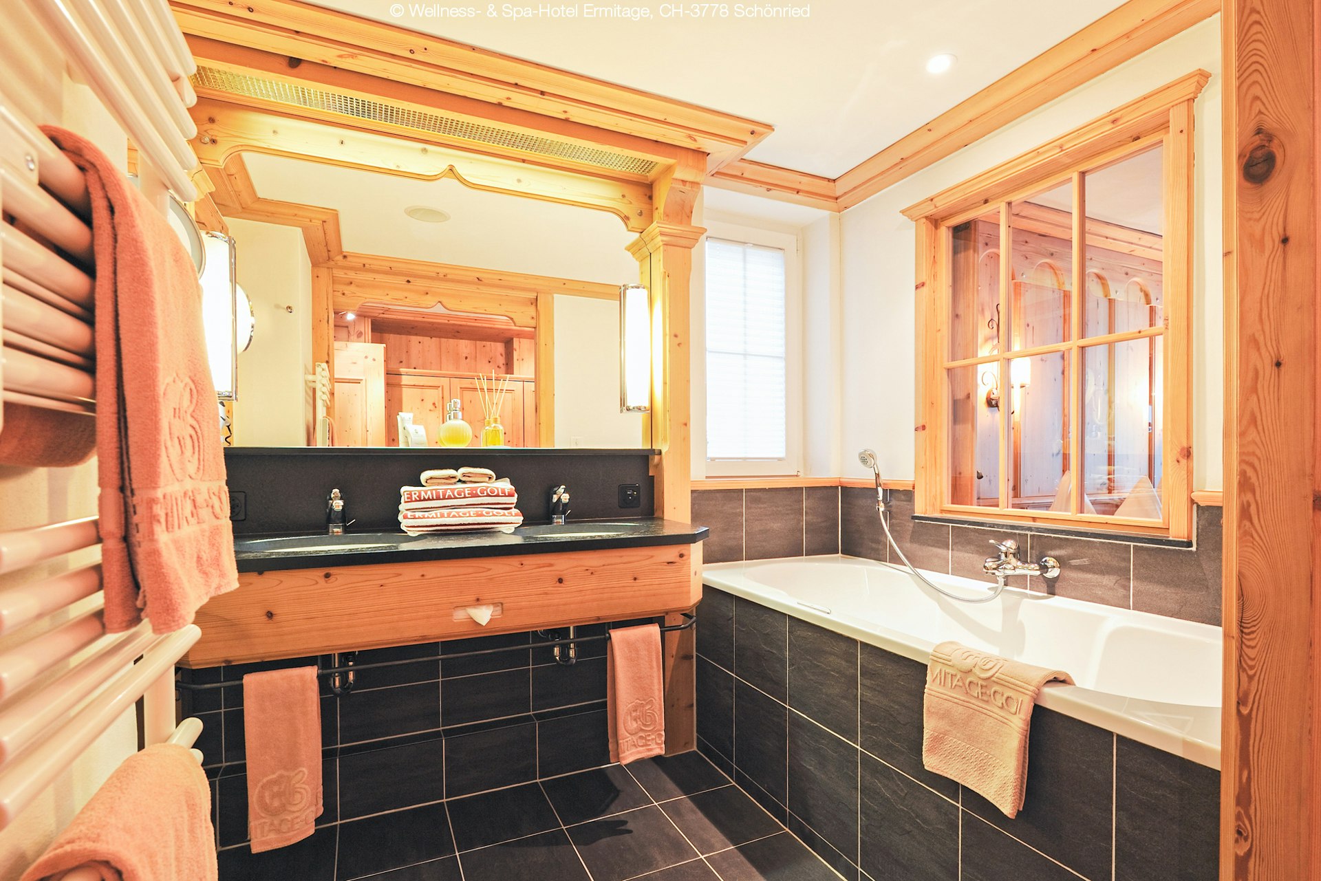 Badezimmer mit Badewanne und zwei Waschbecken, Marmorfliesen