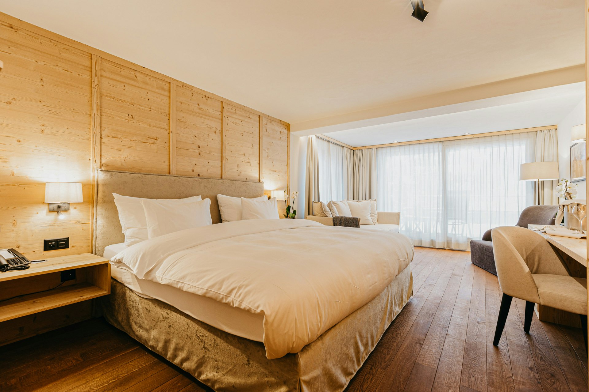 Schlafzimmer mit Doppelbett, Polstersessel und grossem Fenster