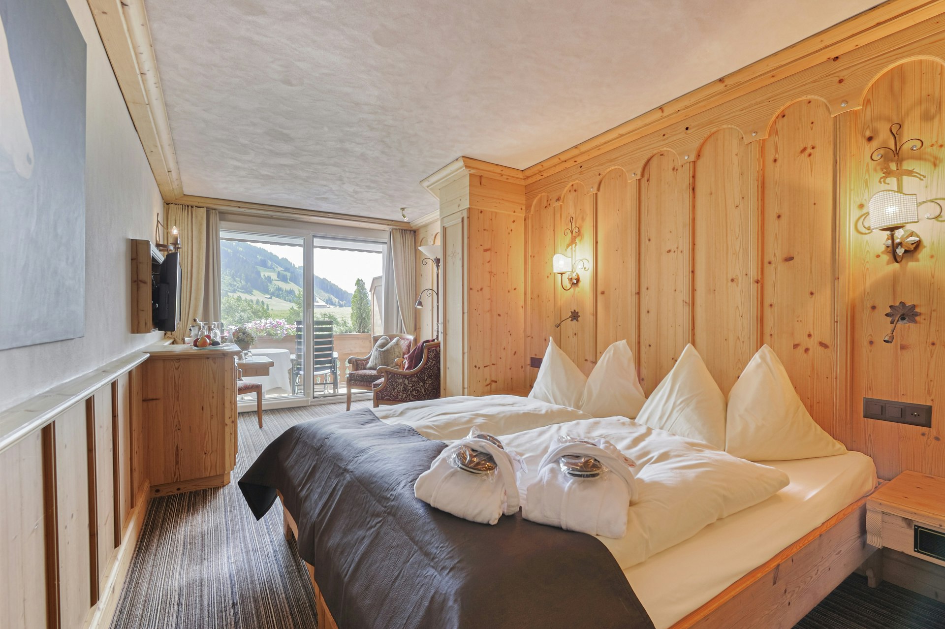 Schlafzimmer mit Doppelbett, Wohnecke und Balkon