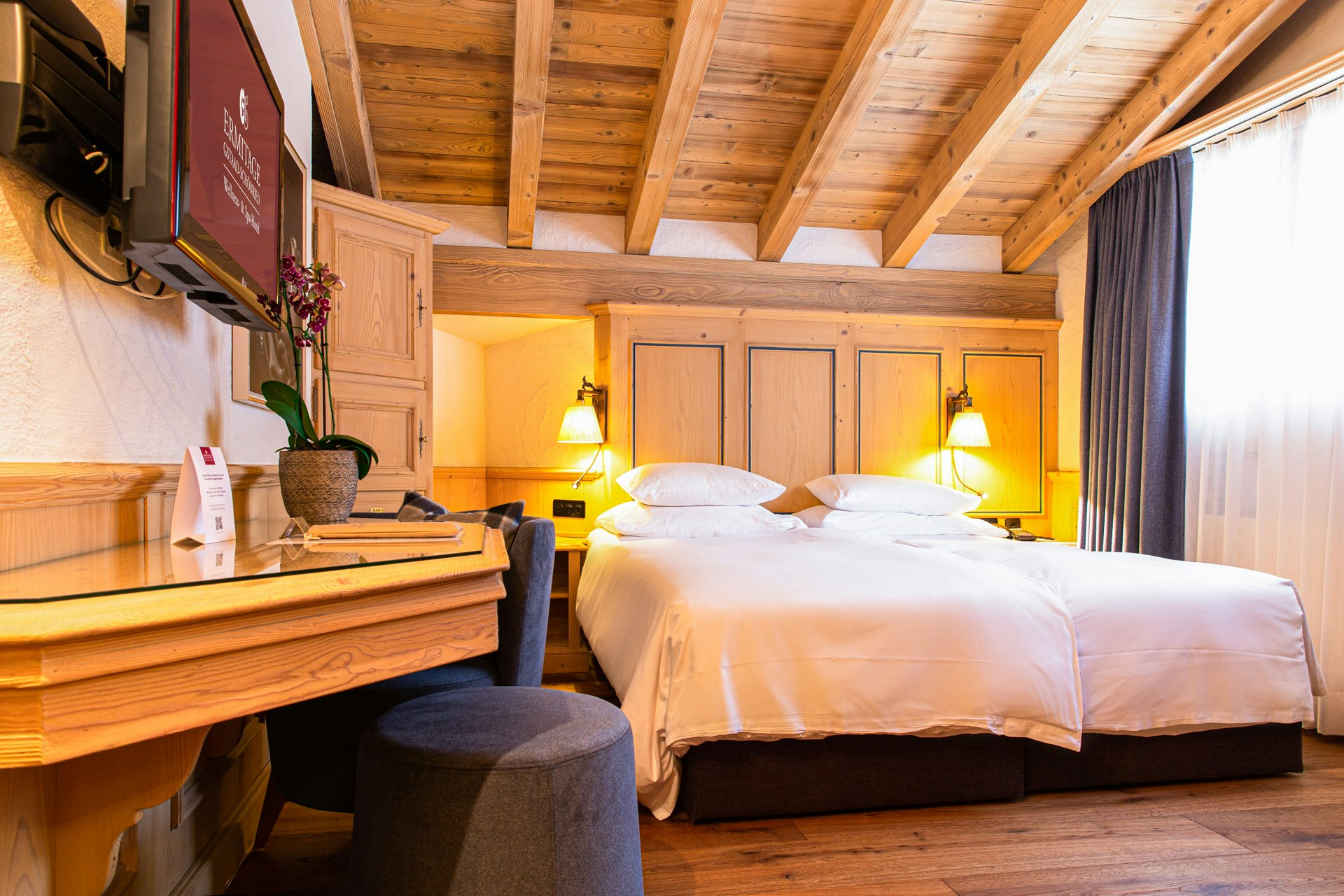 Schlafzimmer mit Doppelbett und Holzdecke und -boden
