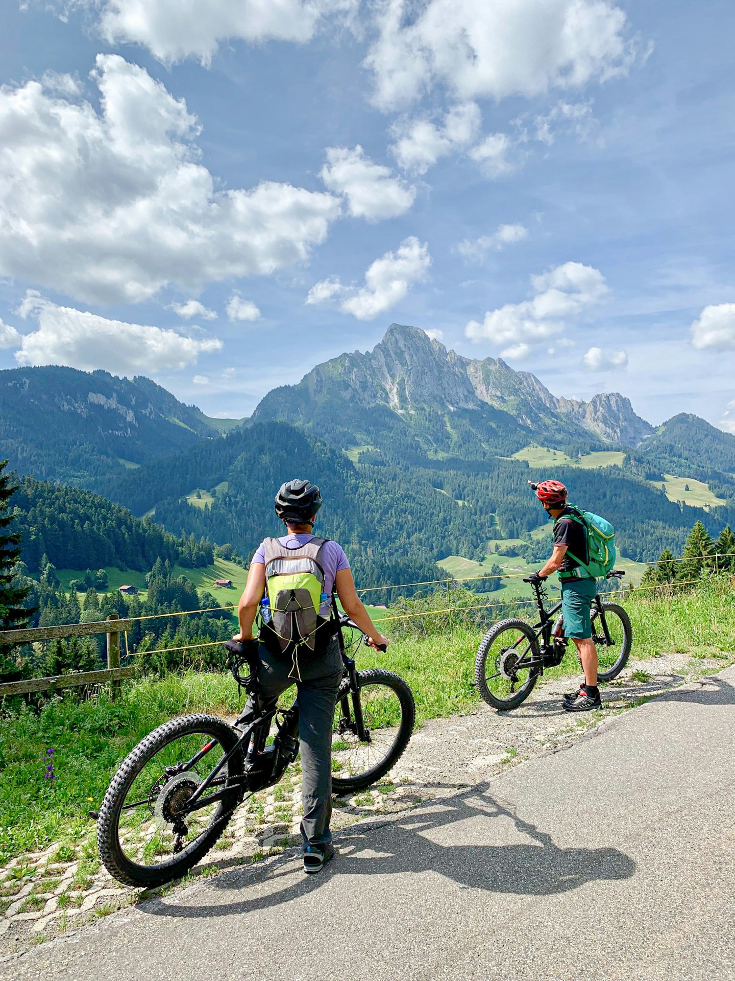 Zwei Menschen auf einem Fahrrad schauen sich die Berglandschaft an
