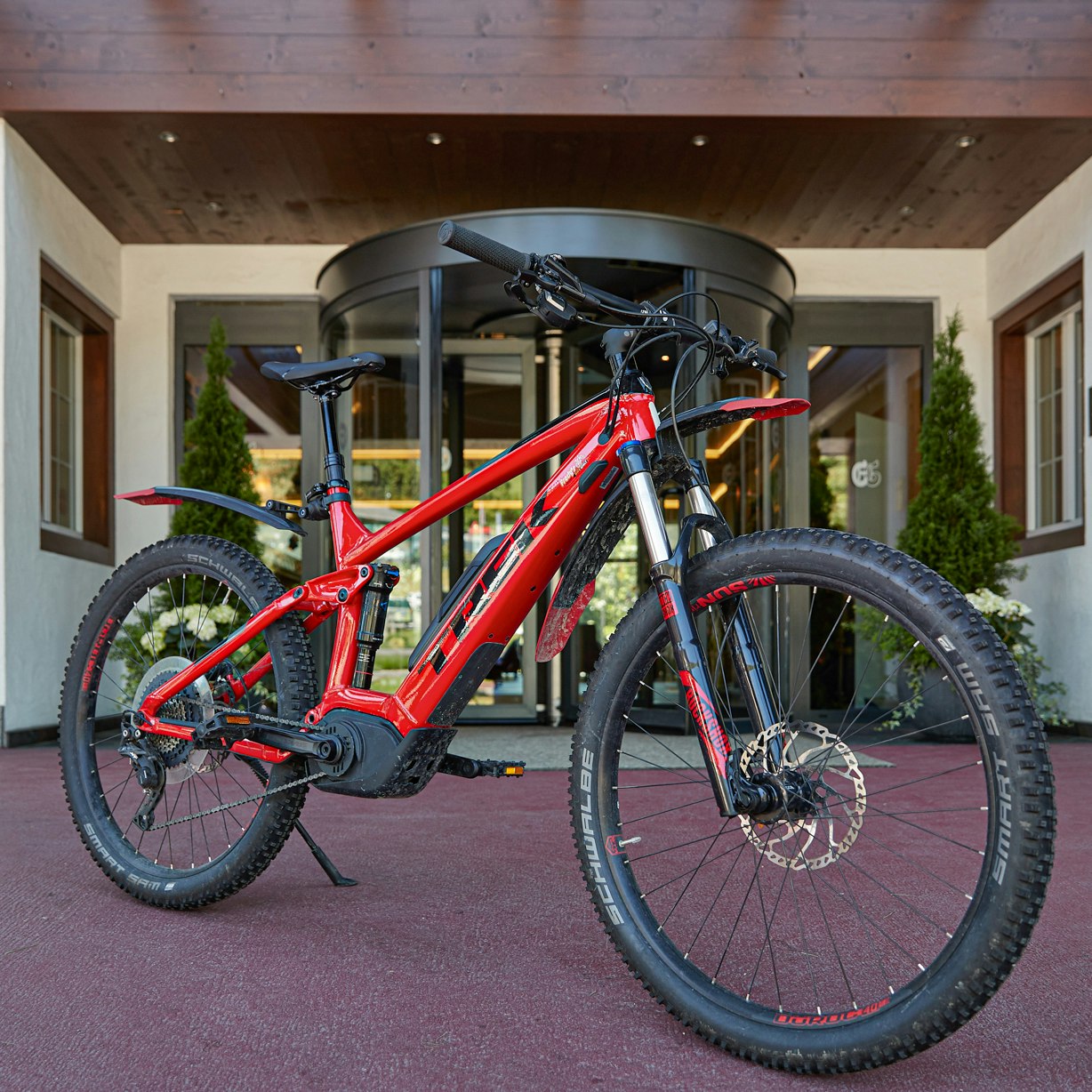 Vélo Ermitage VTT rouge devant l'entrée de l'hôtel