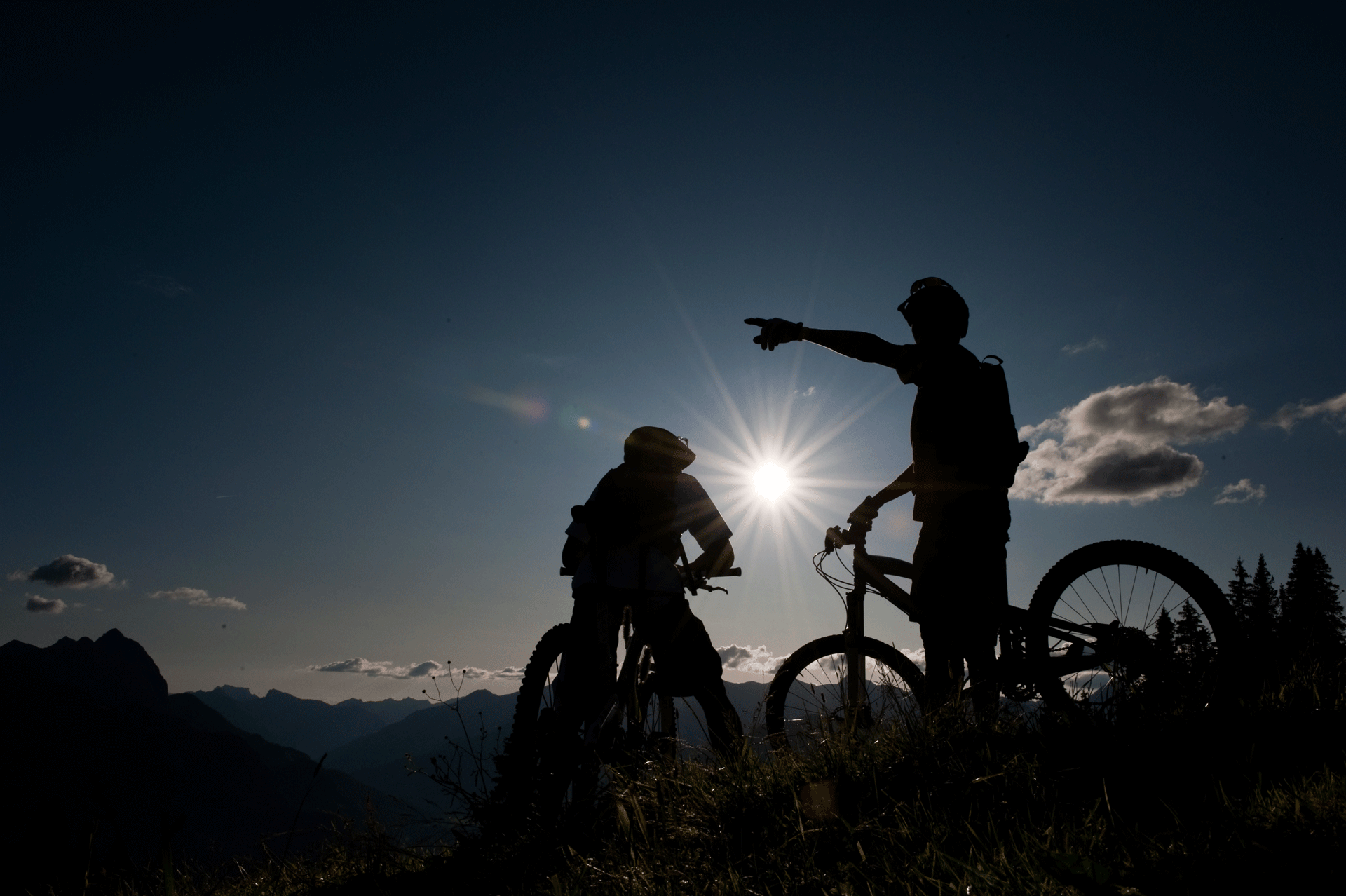 Zwei Radfahrer, die gegen das Sonnenlicht pausieren.
