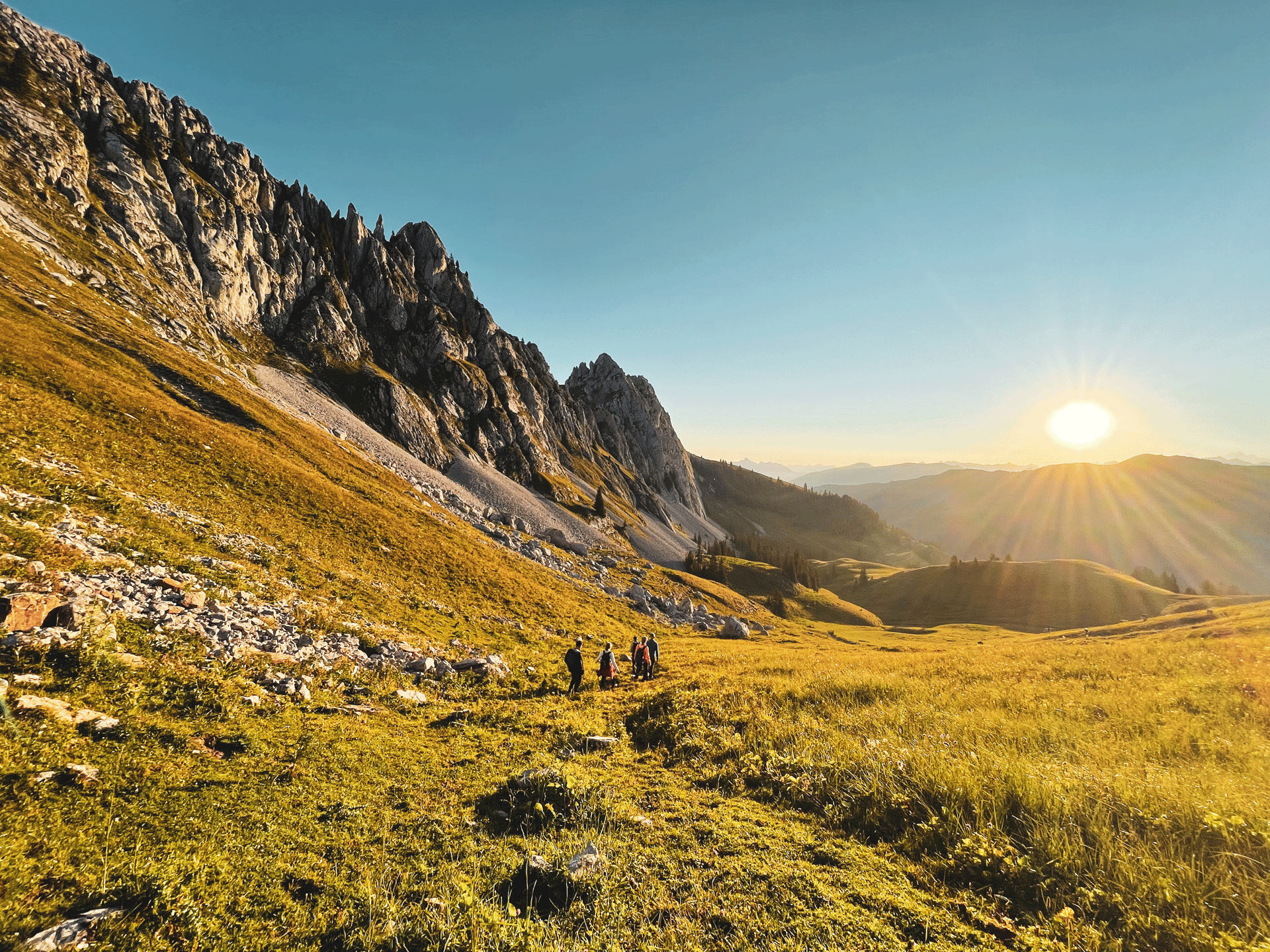 Randonneurs dans un paysage de montagne au lever du soleil