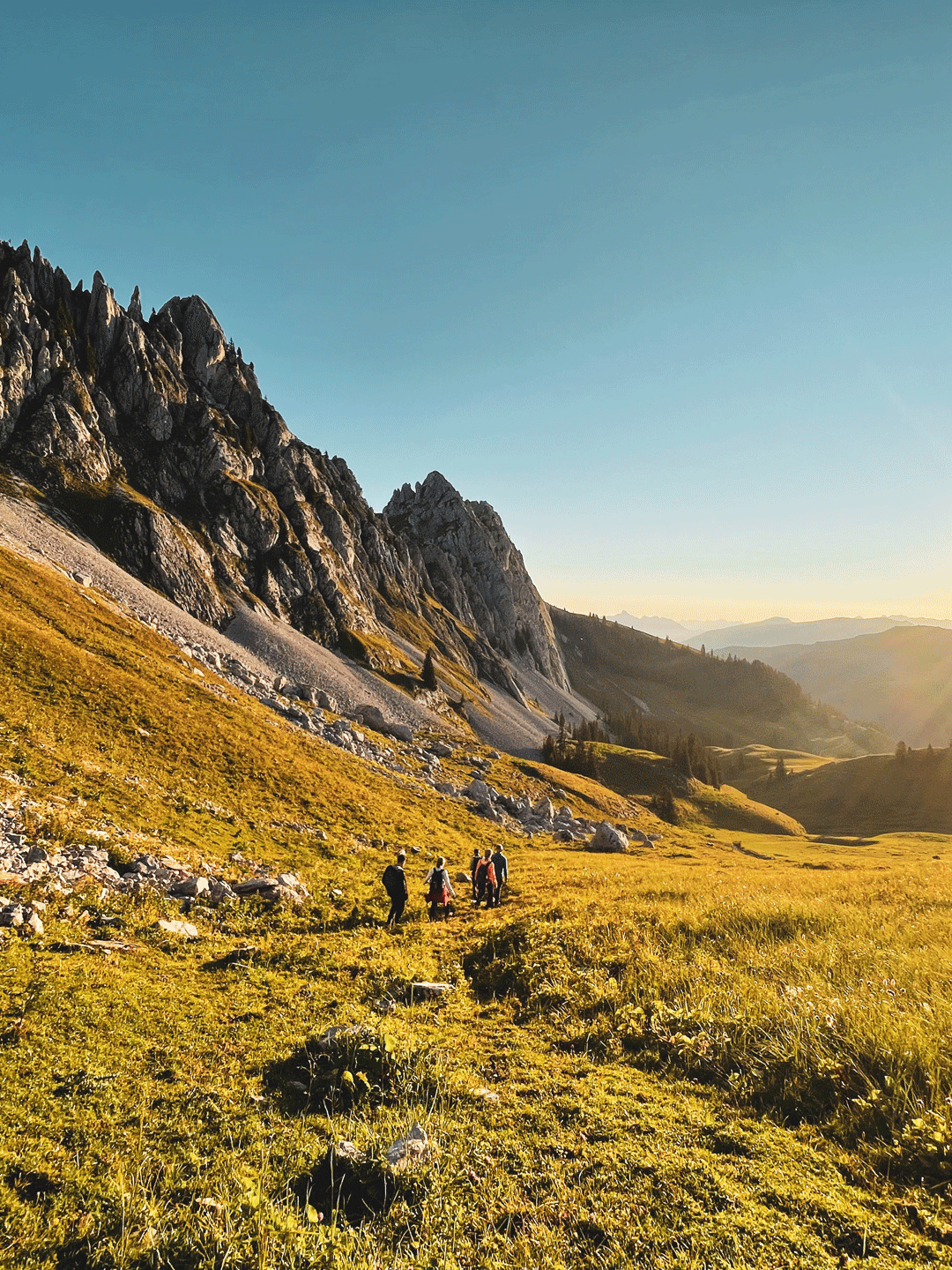 Hiking with the nature guides of the Hotel Ermitage Hikers in a mountain landscape at sunrise