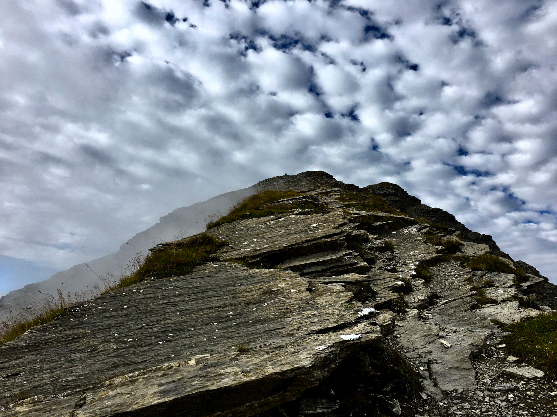 Schroffer Berg mit Schäfchenwolken