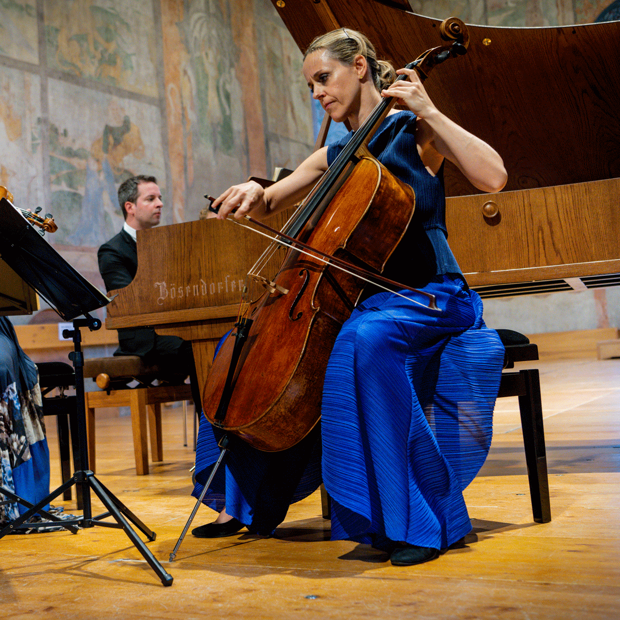 Sol Gabetta am Gstaad Menuhin Festival Eine Frau mit Cello und eine mit Geige werden von einem Klavierspieler begleitet