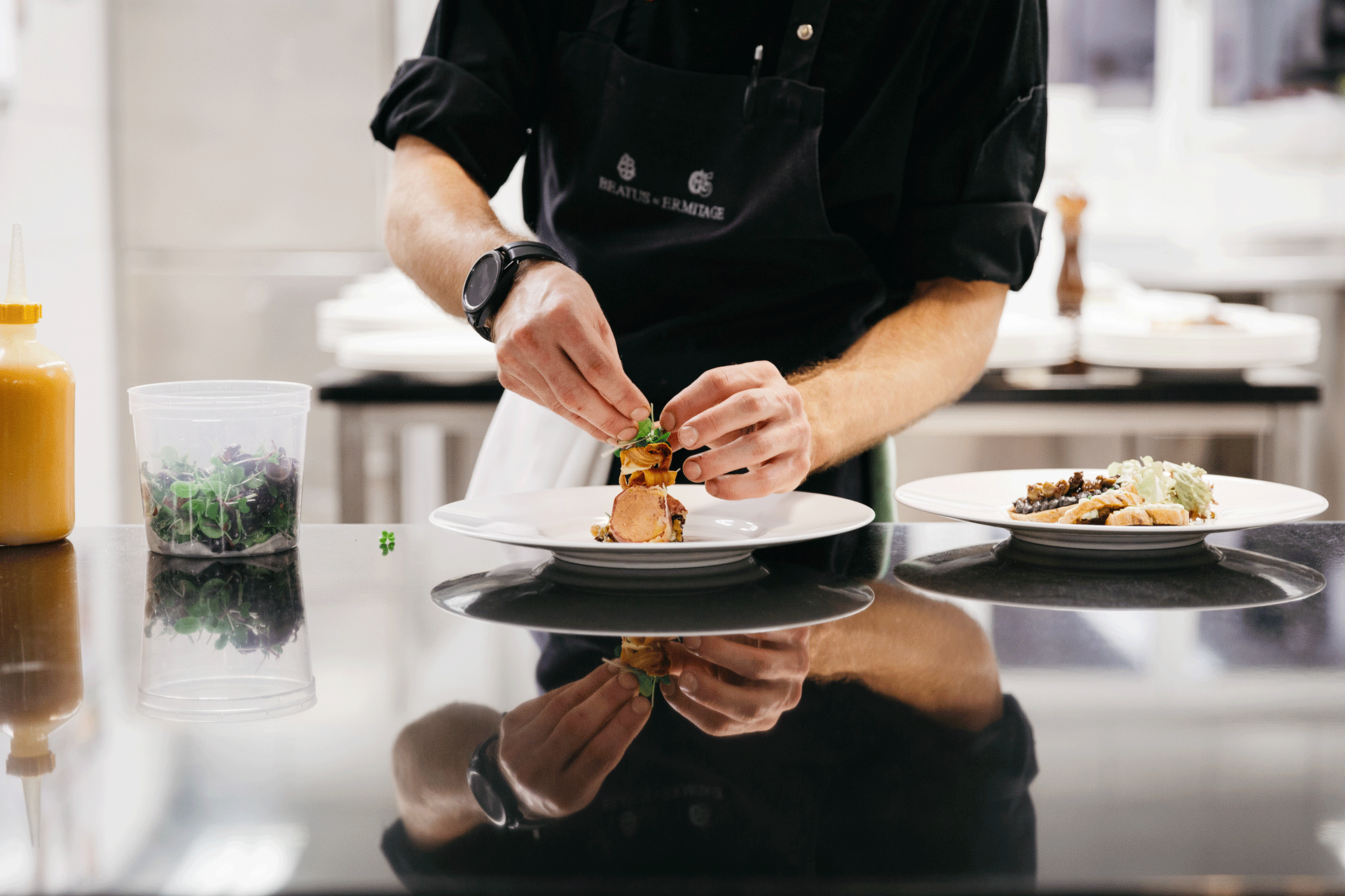 Les mains d'un homme qui dresse un plat dans une assiette