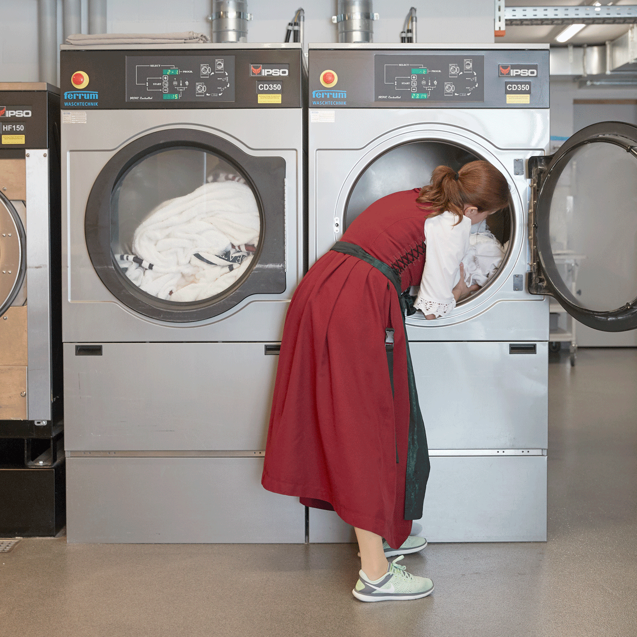 Wäsche im Hotel Ermitage Eine Frau befüllt eine grosse Waschmaschine.