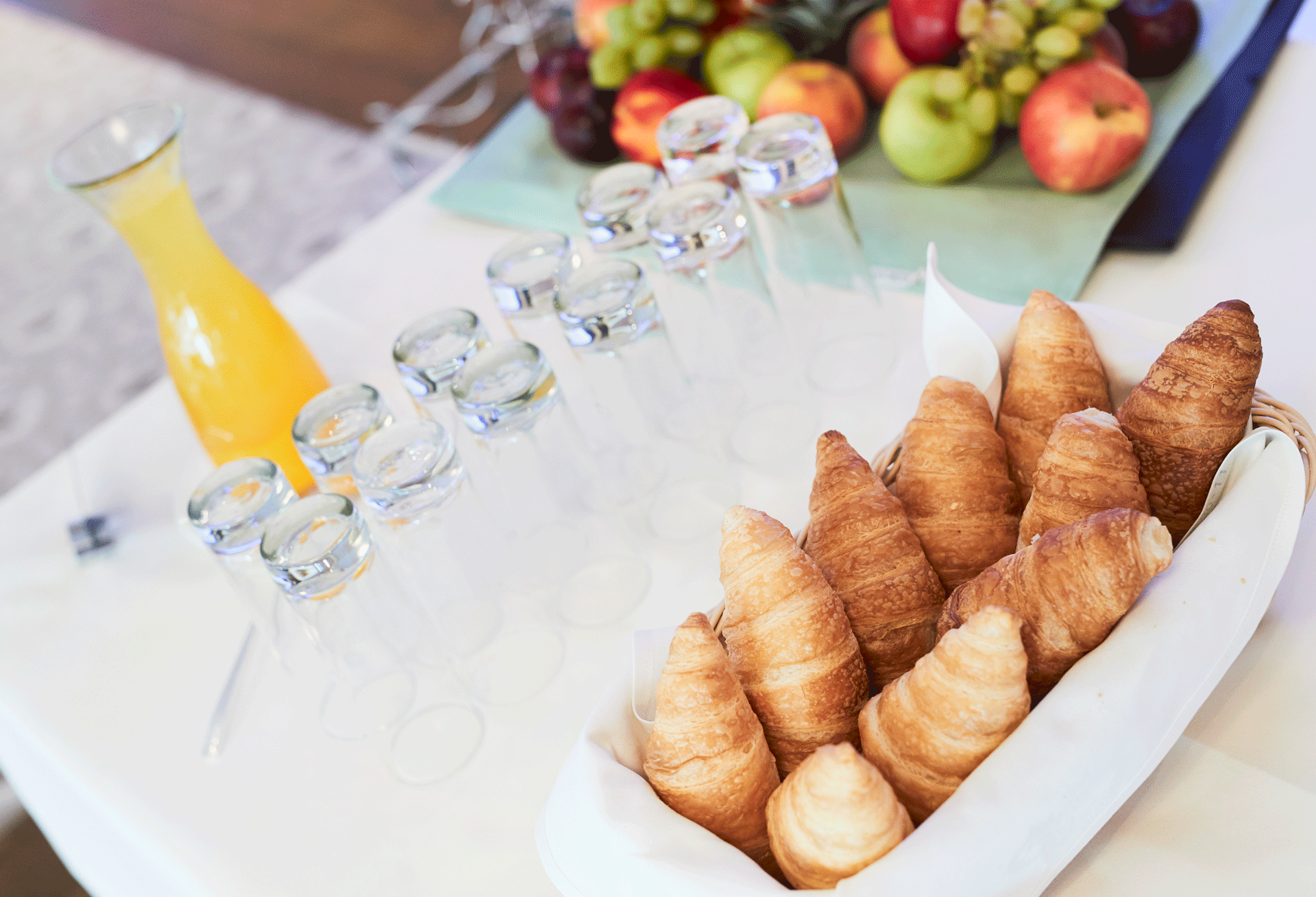 Croissants, Obst, Orangensaft und Gläser