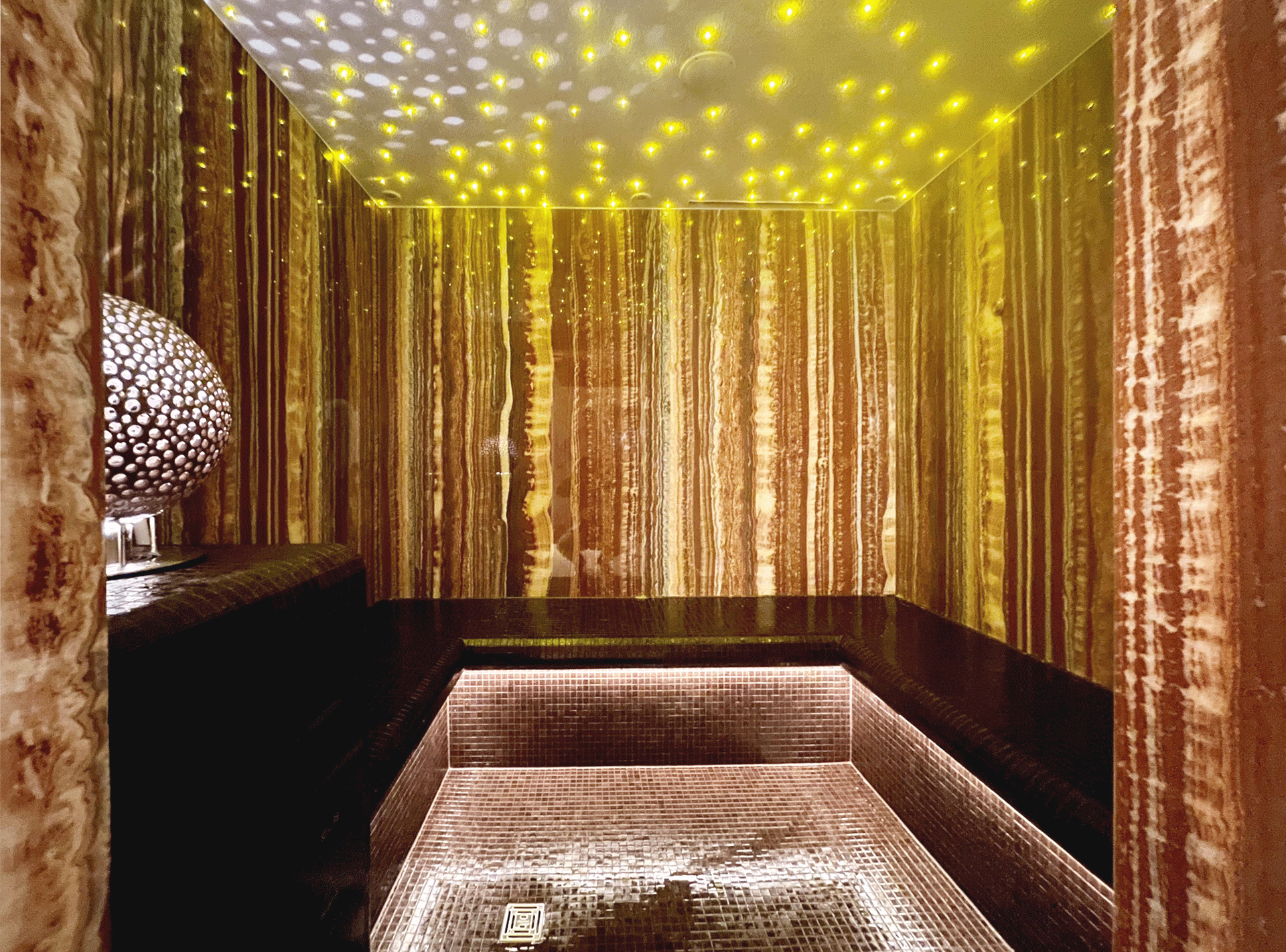Bain de vapeur avec petits carreaux de mosaïque et éclairage scintillant au plafond