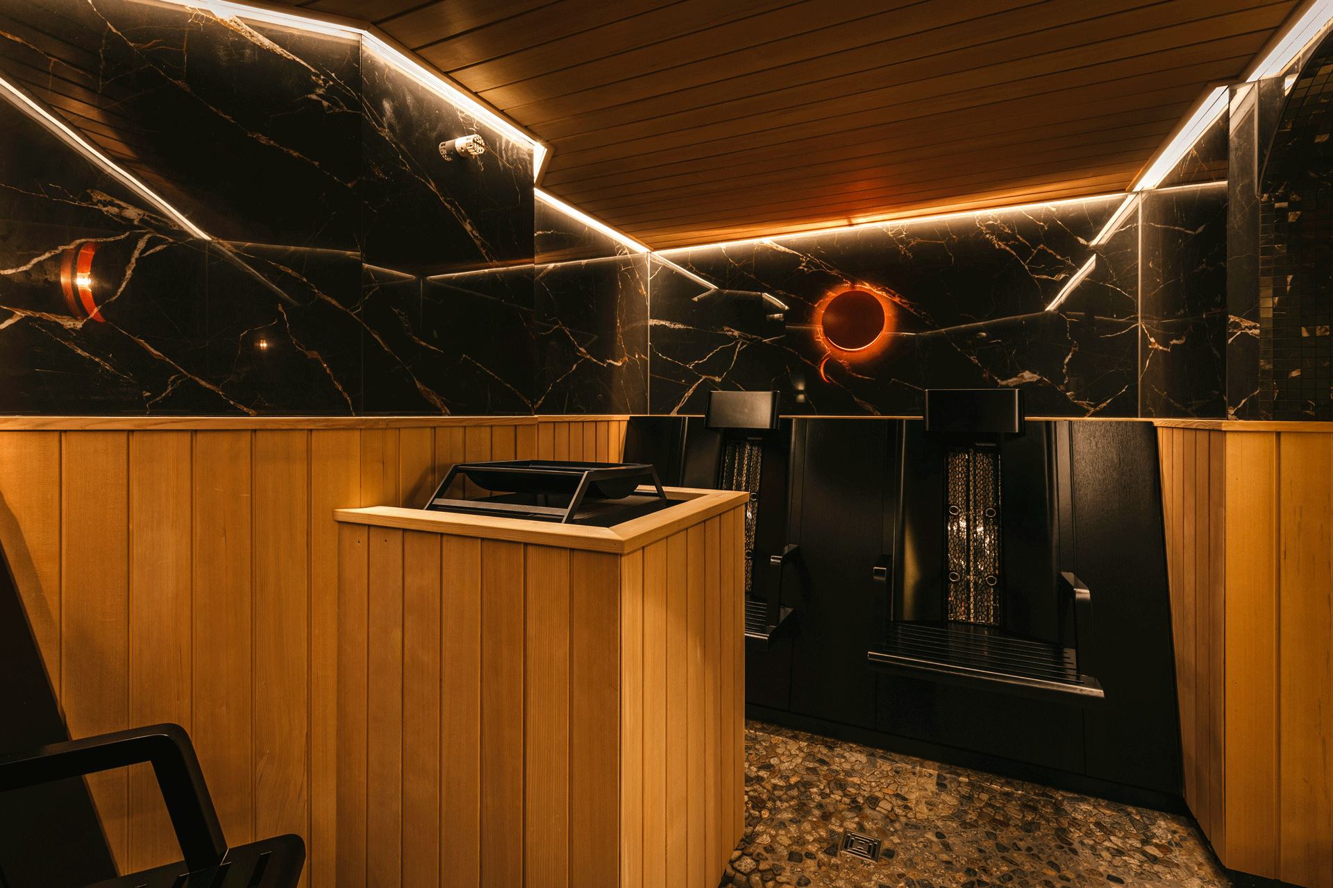 Dunkle Sauna mit Holz und Marmor und Infrarotlampen