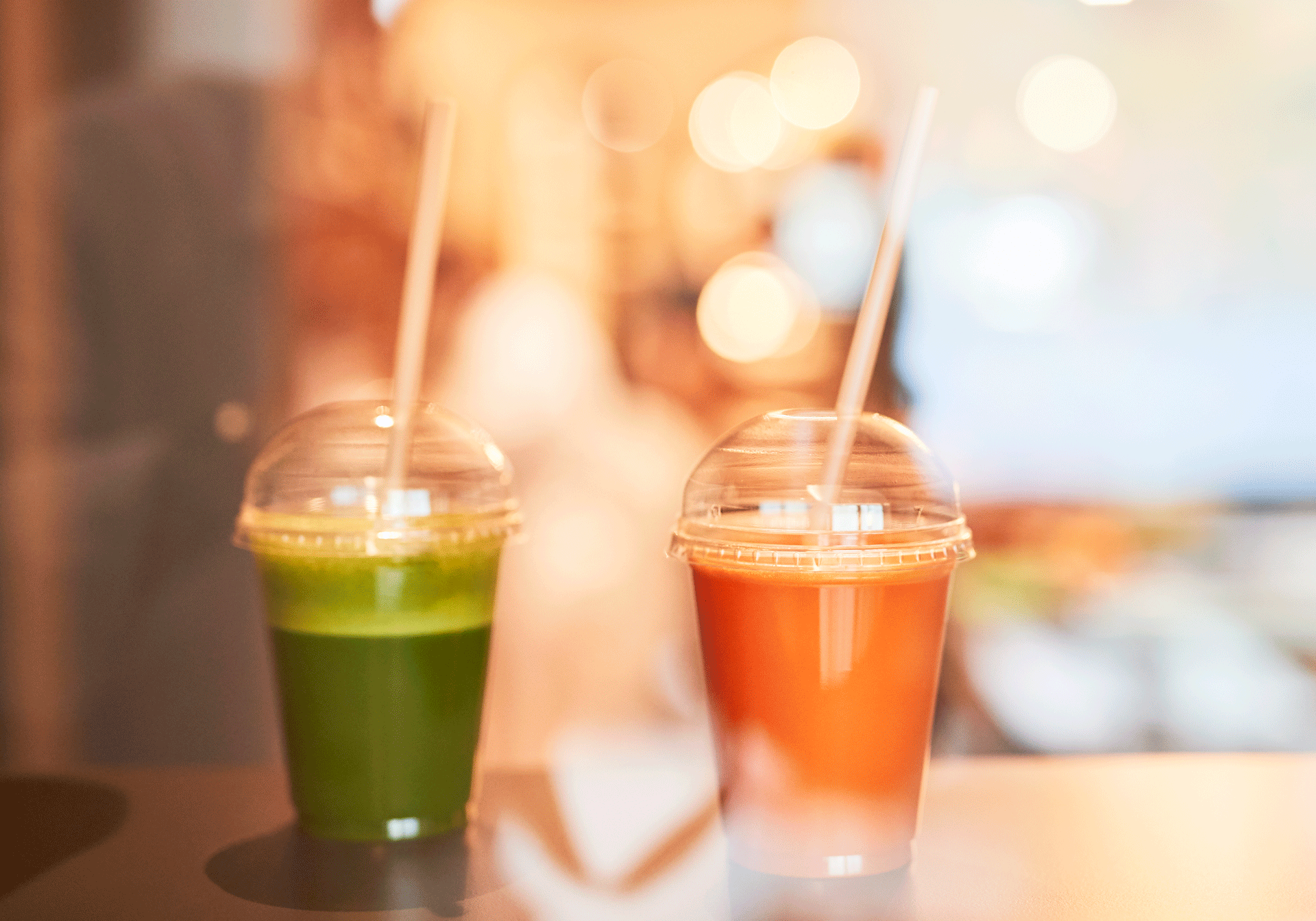 Grüner und oranger Smoothie auf Bar